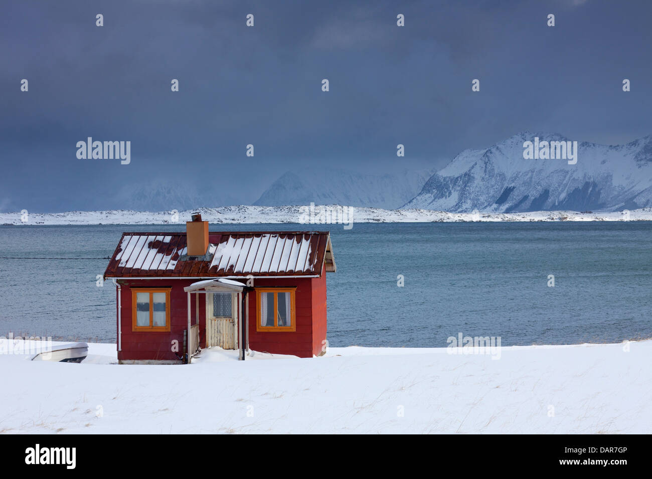 Rot isoliert Holz Rorbuer Kabine entlang der Küste in den Schnee im Winter, Lofoten-Inseln, Nordland, Norwegen, Skandinavien Stockfoto