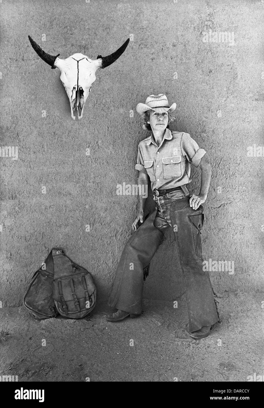 Ein Cowgirl, Leben auf einer kleinen Ranch in Galisteo Becken des nördlichen New Mexico ca. 1974 mit einem Kuh Totenkopf und Satteltaschen Stockfoto