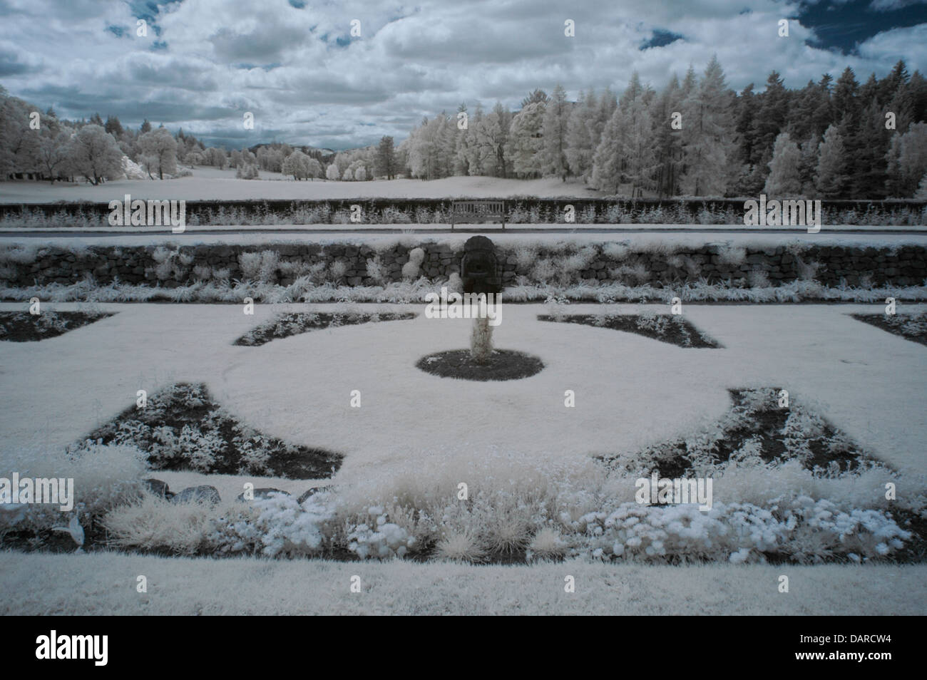 Horizontale Infrarot-Bild des Gartens vor Balmoral Castle, Royal Deeside, Schottland, UK mit Bäumen und Wolken. Stockfoto