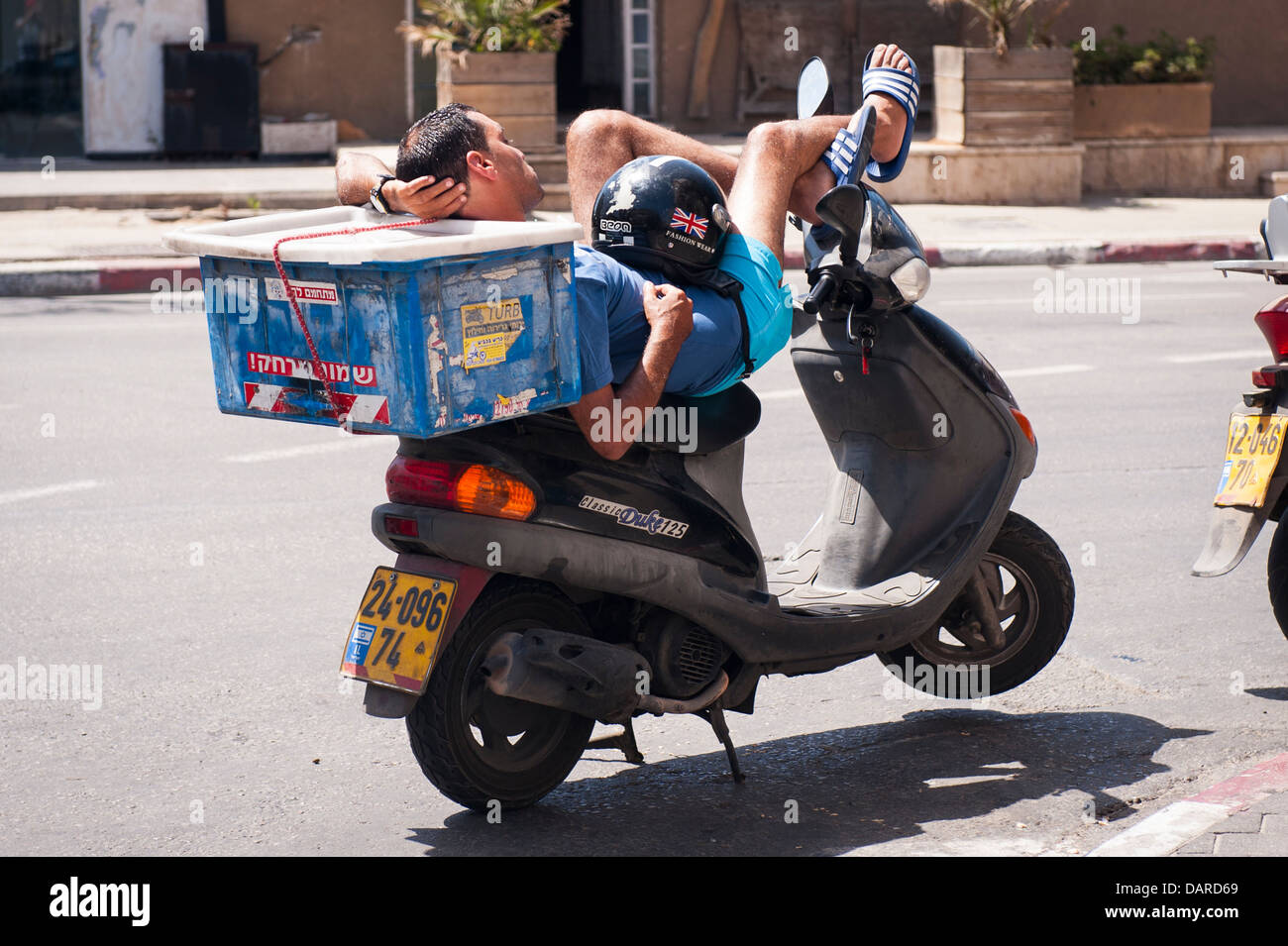 Israel Jaffa Jaffa Pizza Lieferung junge Mann entspannt in der Sonne liegen auf klassischen Herzog 125 Roller moped Motorrad Fahrrad Zyklus Stockfoto