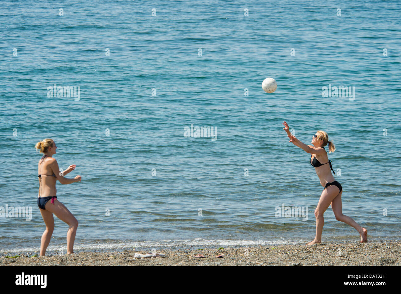 Aberystwyth Wales UK, Donnerstag, 18. Juli 2013.  Zwei Frauen spielen Sie Volleyball am Strand in der Nähe des Meeres am Aberystwyth, an der Westküste Wales, UK den Zauber von hohem Druck und mit feinen trockenen Sonnenschein und Temperaturen in den hohen 20er Jahren Celsius, soll für eine Woche oder zehn Tage weiter markieren die längste Periode des guten Sommerwetter im Vereinigten Königreich seit 2006. Warnungen im Großteil des Landes über die Gefahren von hohen Temperaturen an den jungen, Kranken und älteren Kredit ausgestellt worden: Keith Morris/Alamy Live-Nachrichten Stockfoto