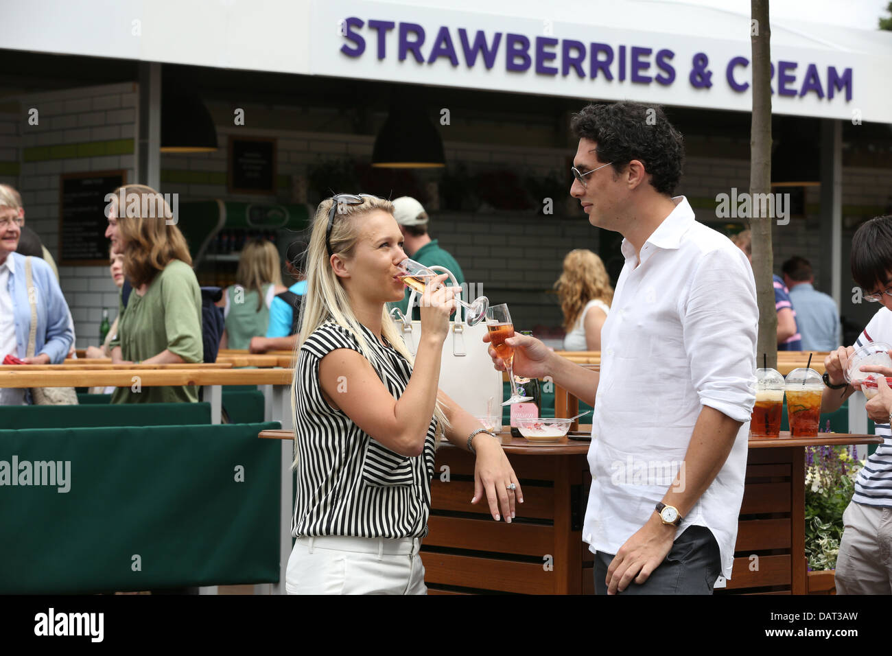 Ein paar genießen Sie Champagner der Erdbeeren und Sahne auf Wimbledon Tennis Championships 2013 Stockfoto