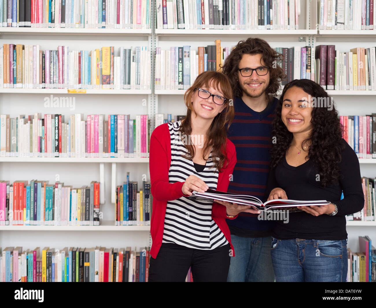 Multi ethnischen Gruppe von Menschen halten Buch in einer Bibliothek Stockfoto