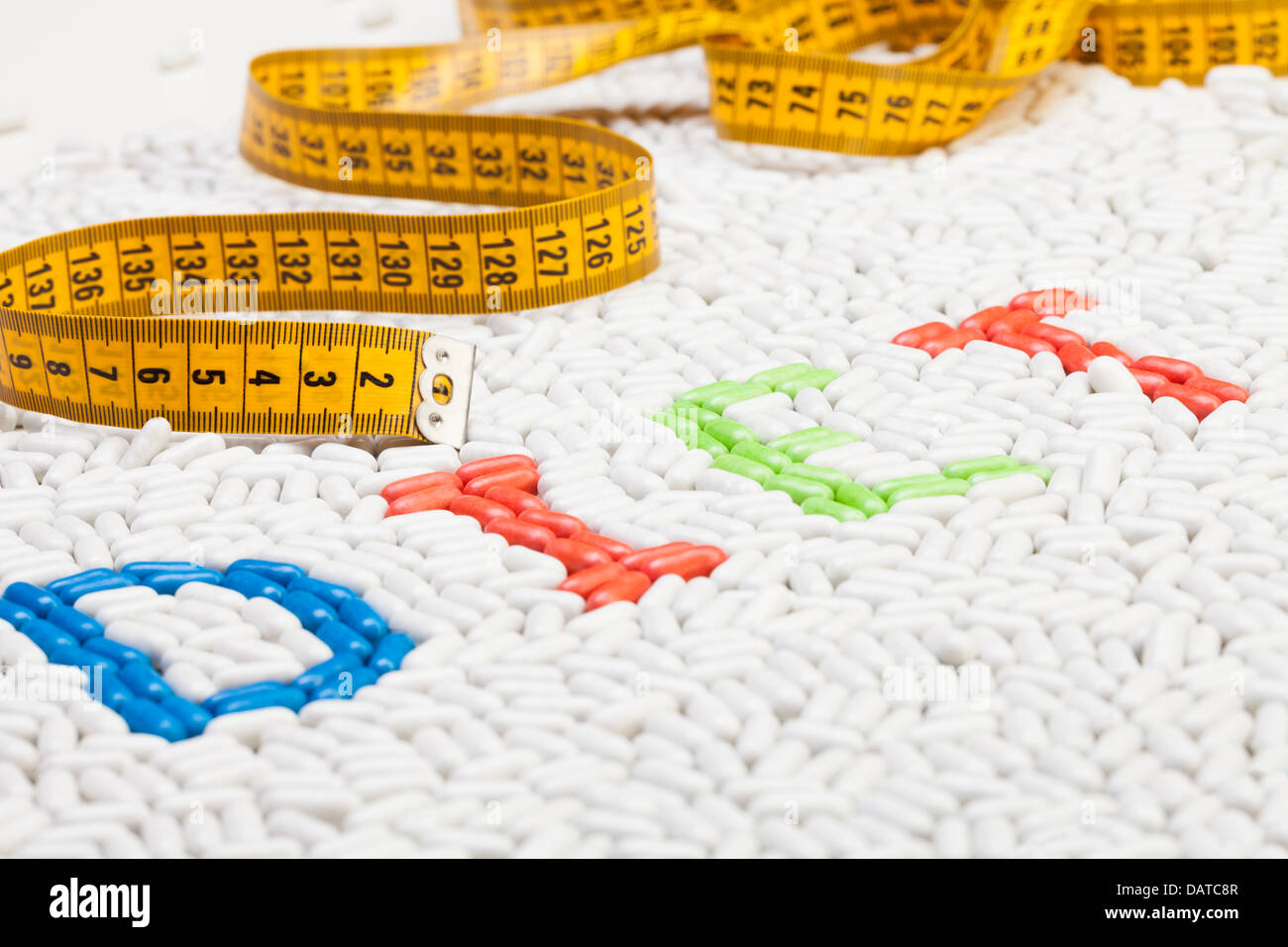 Diät-Word-Text gemacht von Tabletten und Pillen Medikamente in verschiedenen Farben, die zusammen als Mosaik mit Zentimeter auf Hintergrund Stockfoto