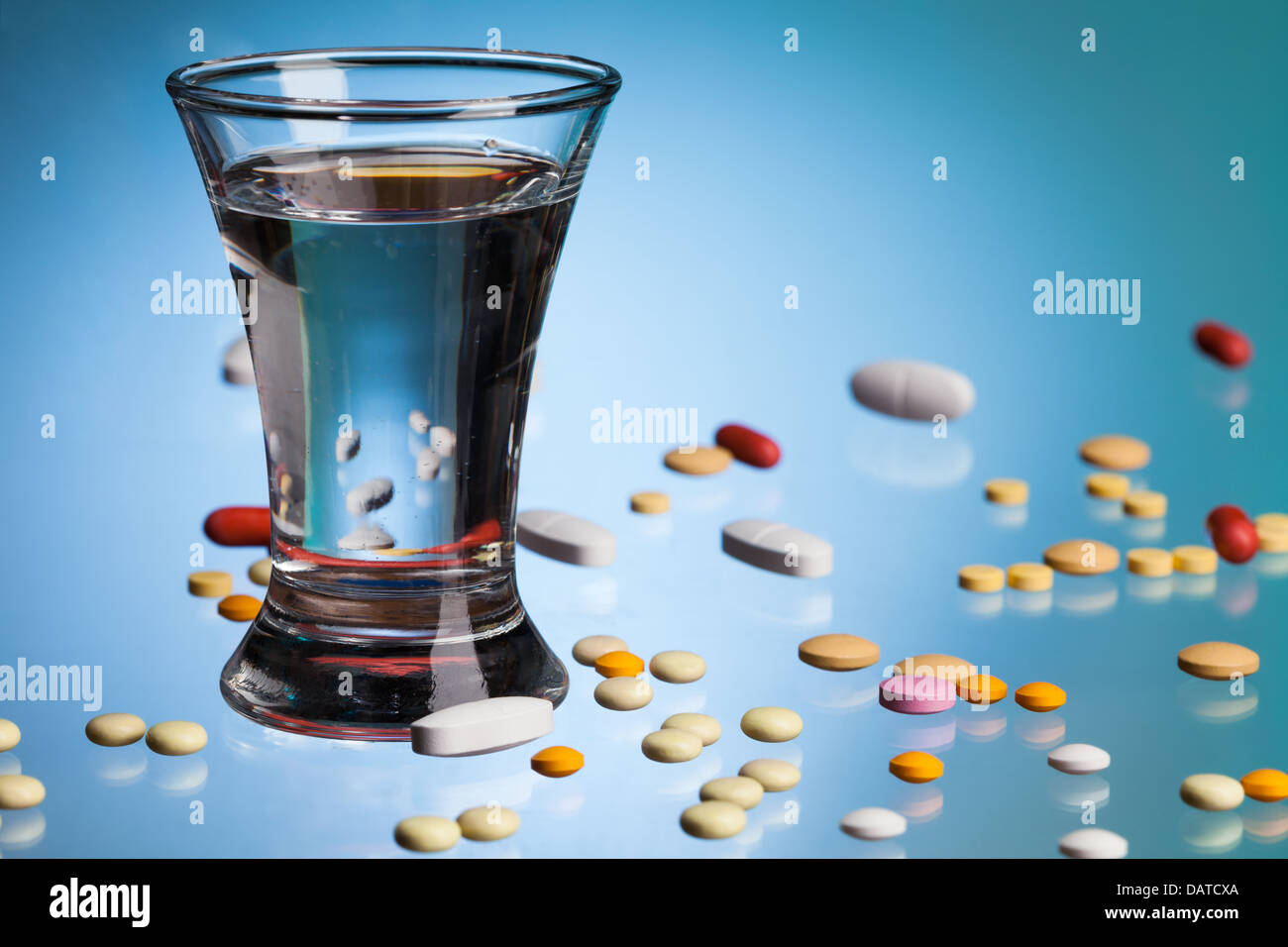 Glas Wasser zum trinken, Drogen, Tabletten und Pillen auf blauer Tisch  Stockfotografie - Alamy