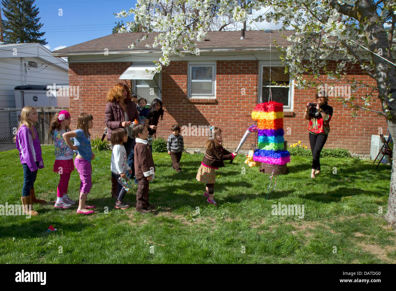 Kinder schlagen eine Piñata bei einer hispanischen Kinder-Geburtstagsparty in Boise, Idaho, USA. Stockfoto