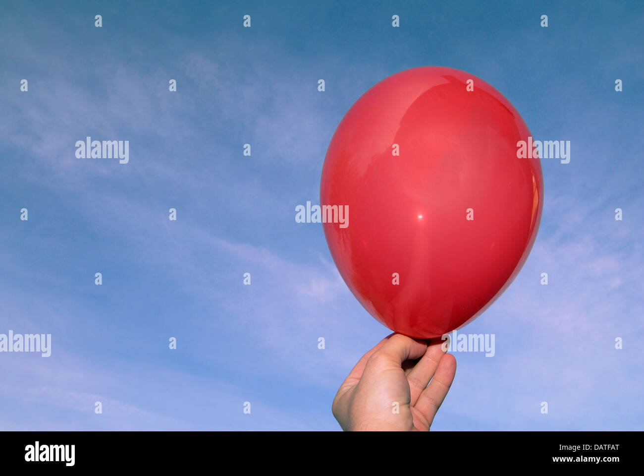 Einen roten Ballon Besitz ein mans Hand in blauen Himmel wird freigegeben Stockfoto