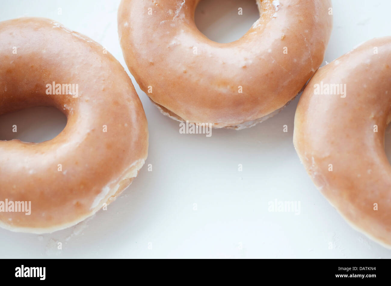 Frisch zubereitete warme Donuts mit Zuckerguss und am Rand des Rahmens aus nächster Nähe. Stockfoto