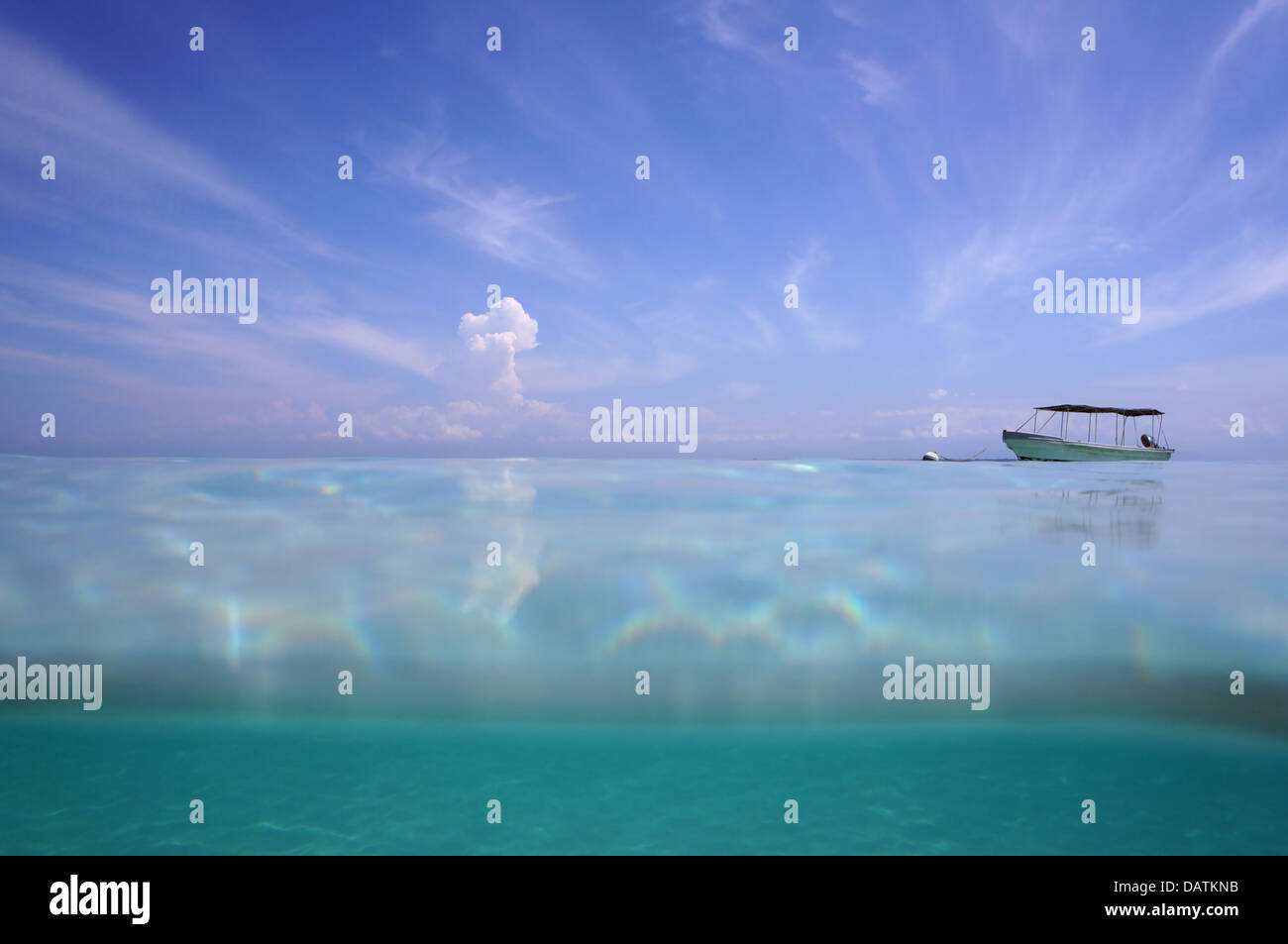 Horizont von der Wasseroberfläche auf blauer Himmel mit Wolken und ein Boot allein in der Karibik Stockfoto