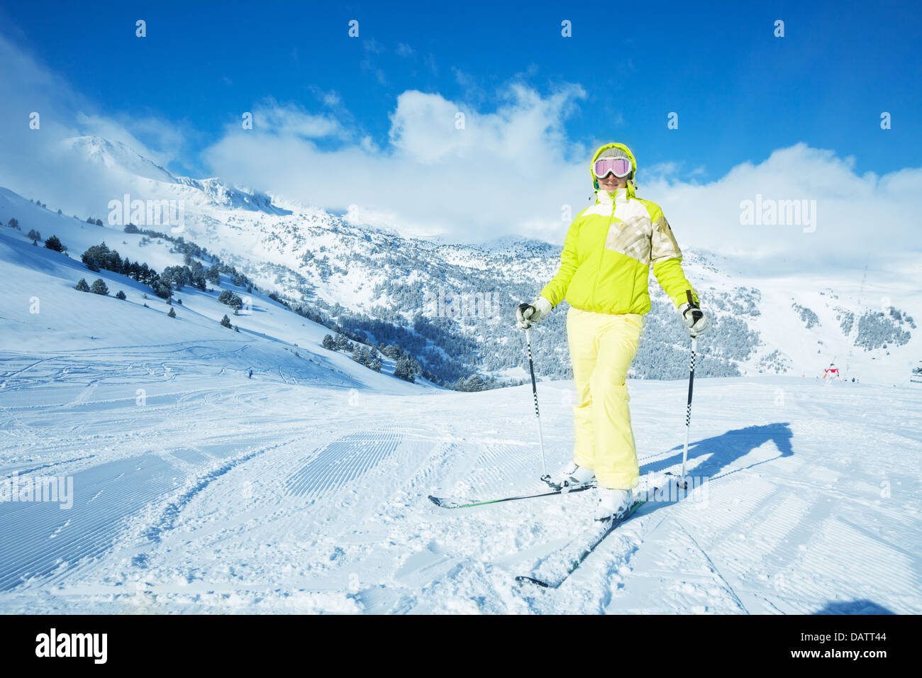 Glückliche Frau helle Sportswear auf den Berghang zur Abfahrt bereit stehen Stockfoto