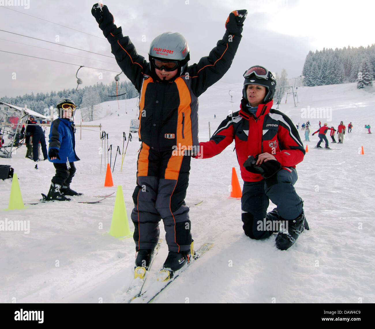 Ein Skilehrer schiebt sanft bergab ein Kind während einer SBZ-Skikurs für Kinder in Missen, Deutschland, 28. Dezember 2007. Foto: Rolf Schultes Stockfoto