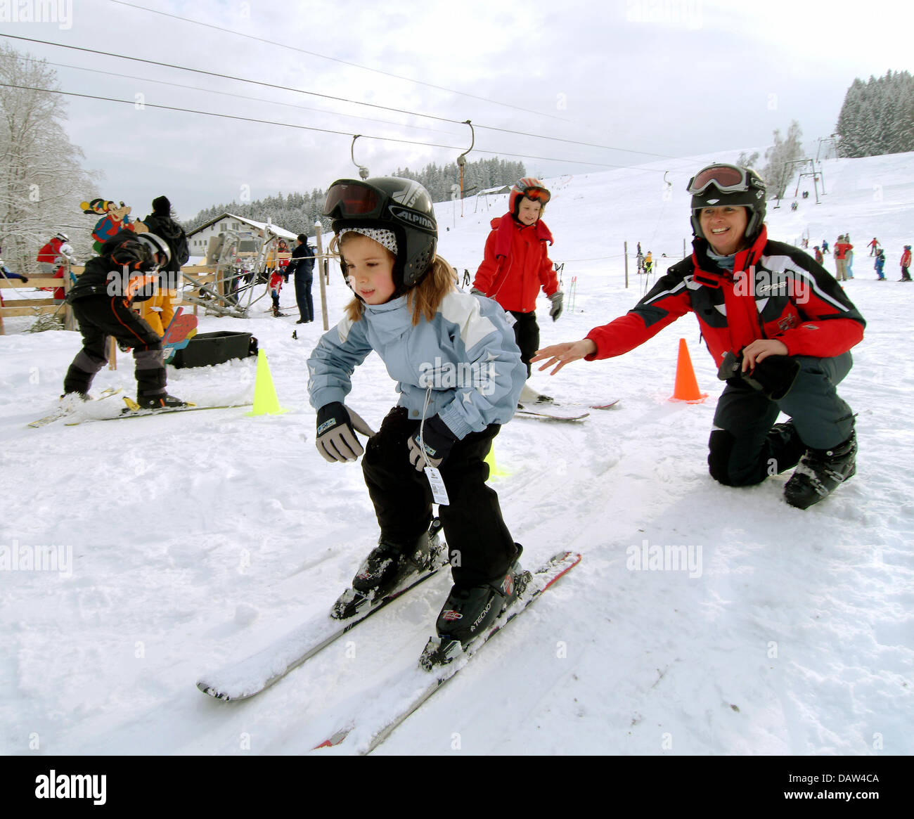 Ein Skilehrer schiebt sanft bergab eine Mädchen während eines SBZ-Skikurs für Kinder in Missen, Deutschland, 28. Dezember 2007. Foto: Rolf Schultes Stockfoto