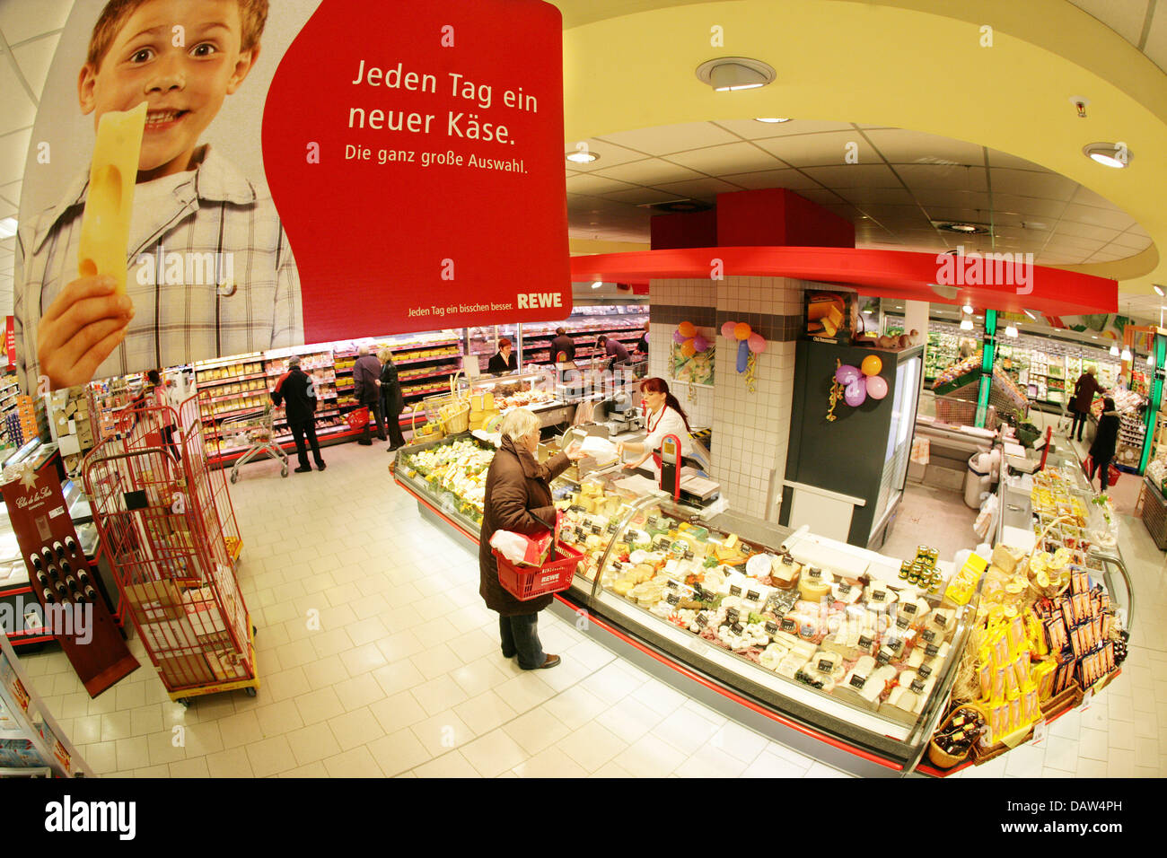 Ein Kunde blickt auf das breite Spektrum an Käsesorten in einem gekühlten Regal in einem umgebauten REWE Supermarkt Laden in Köln, Deutschland, 19. Januar 2007. Foto: Rolf Vennenbernd Stockfoto