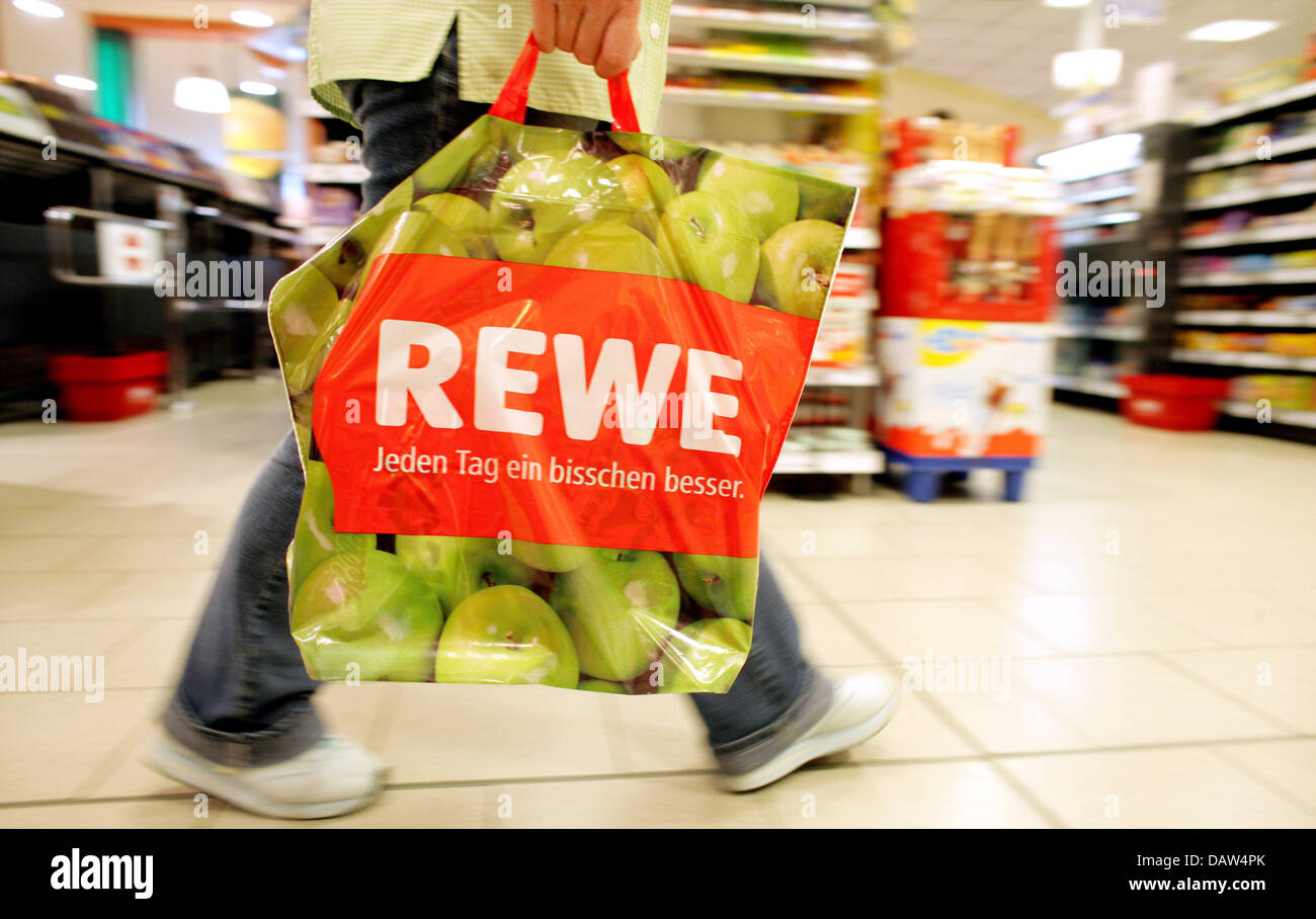 Ein Kunde trägt eine shoppin Plastiktüte mit dem REWE-Logo in einem  umgebauten REWE Supermarkt Laden in Köln, Deutschland, 19. Januar 2007.  Foto: Rolf Vennenbernd Stockfotografie - Alamy