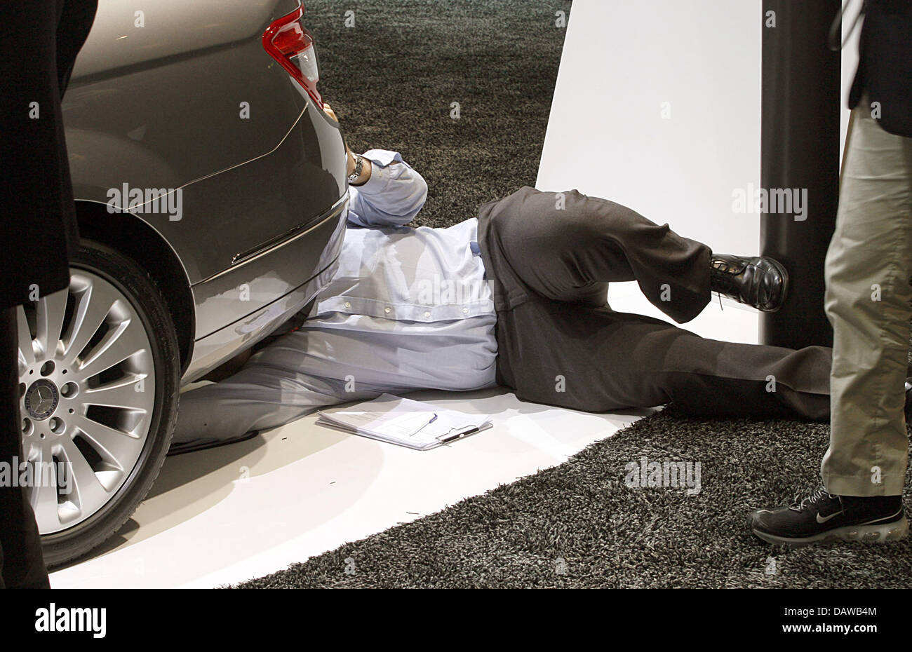 Der Mann Fotografieren Sie den Unterboden ein Mercedes C 280 auf dem Genfer Automobilsalon in Genf, Schweiz, 7. März 2007. Die 2007 läuft Geneva Motor Show vom 08 bis 18. März. Foto: Uli Deck Stockfoto