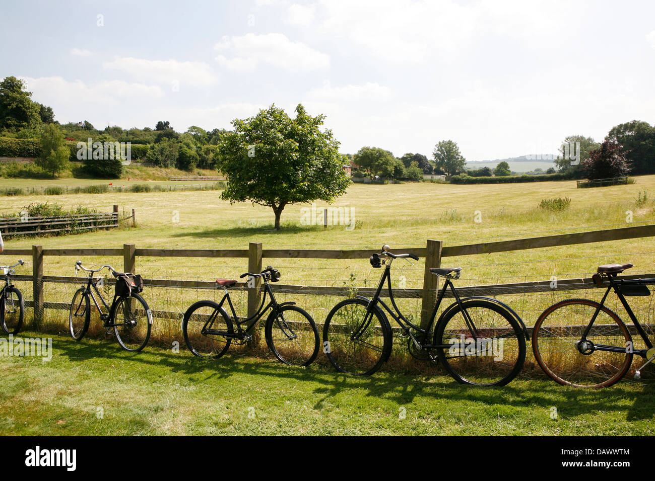 Vintage Fahrräder gegen einen Holzzaun in offener Landschaft Oxfordshire Stockfoto
