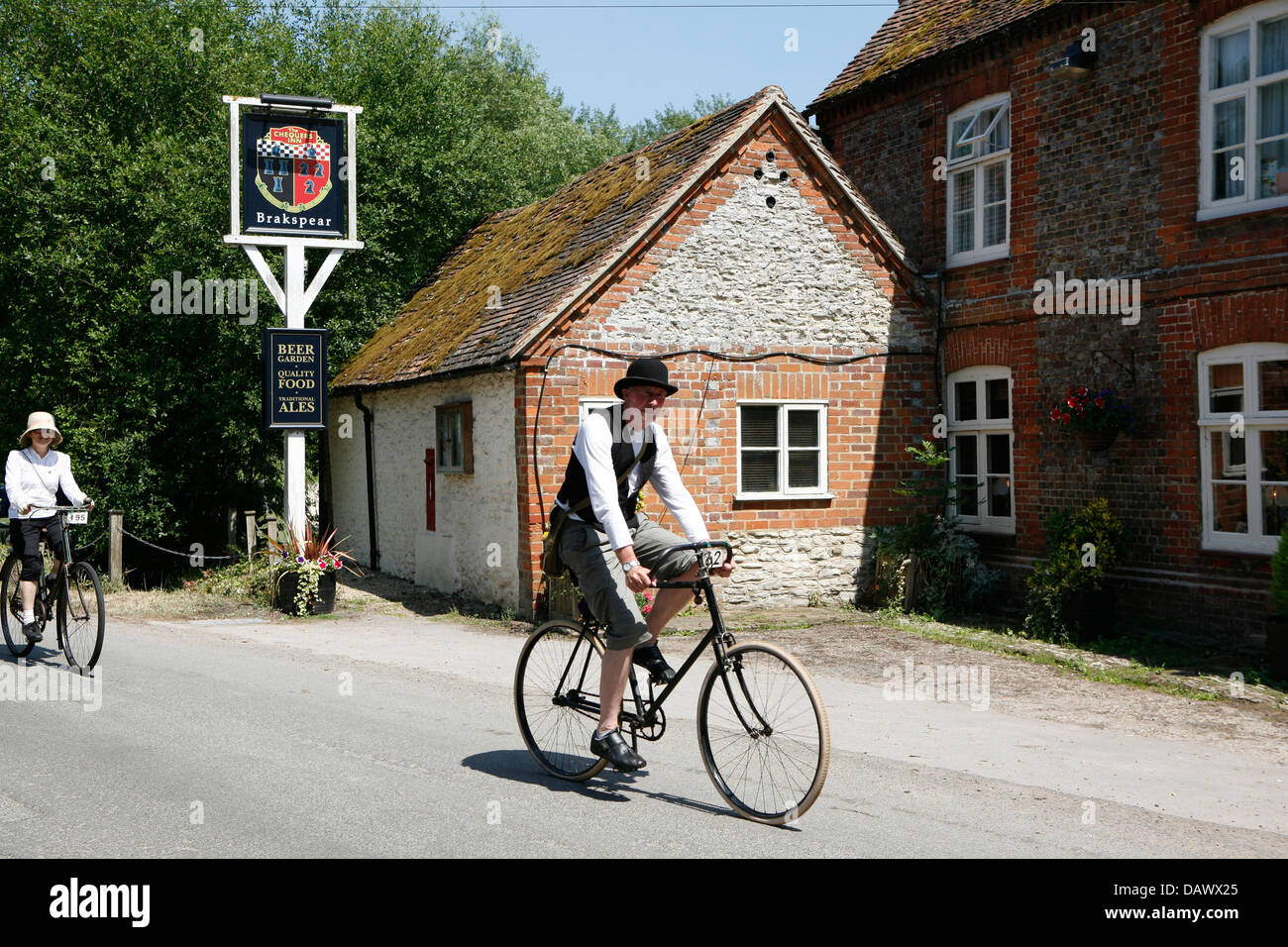 Oldtimer Fahrrad geritten von einem Mann im Zeitraum Outfit. Stockfoto