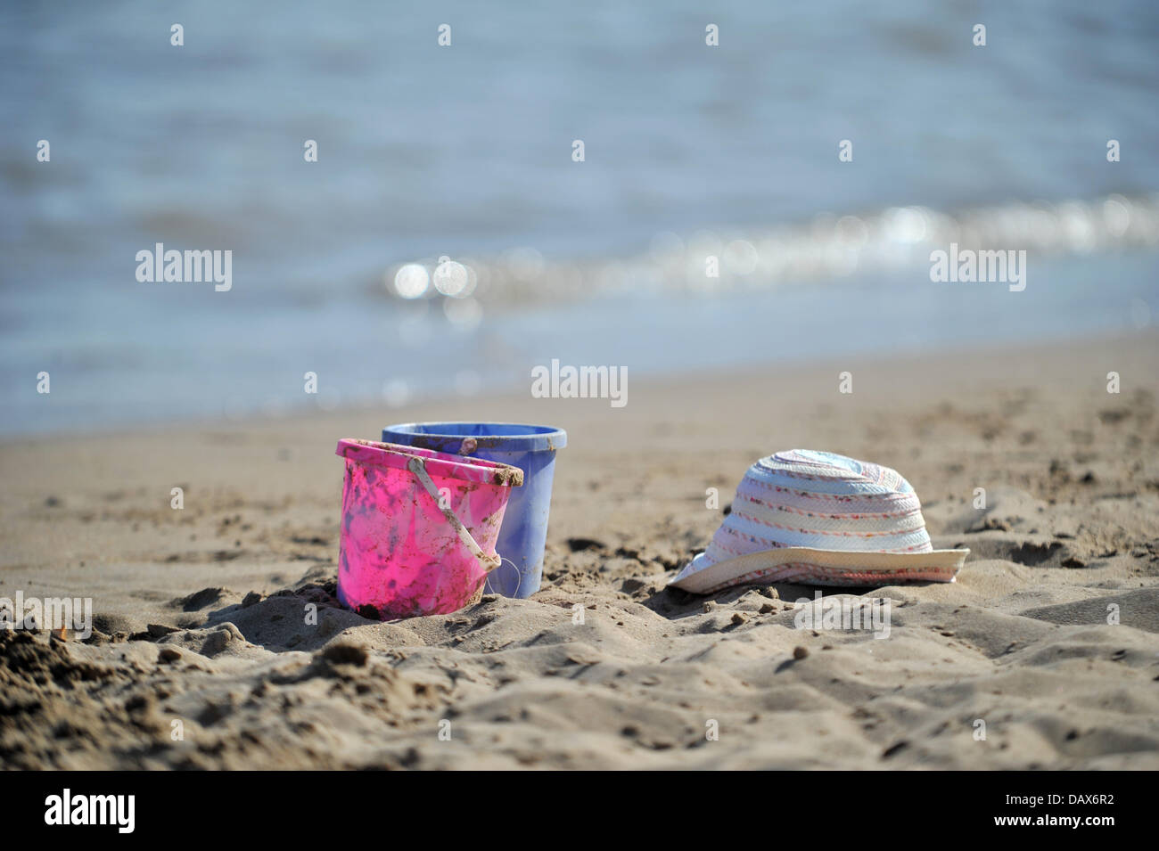 BARRY ISLAND, VEREINIGTES KÖNIGREICH. 19. Juli 2013. Die britische Hitzewelle weiter und die Menschen strömen zu den Stränden in Süd-Wales. Foto zeigt Eimer und einen Hut auf dem Sand links. Foto Credit: Polly Thomas / Alamy Live News Stockfoto