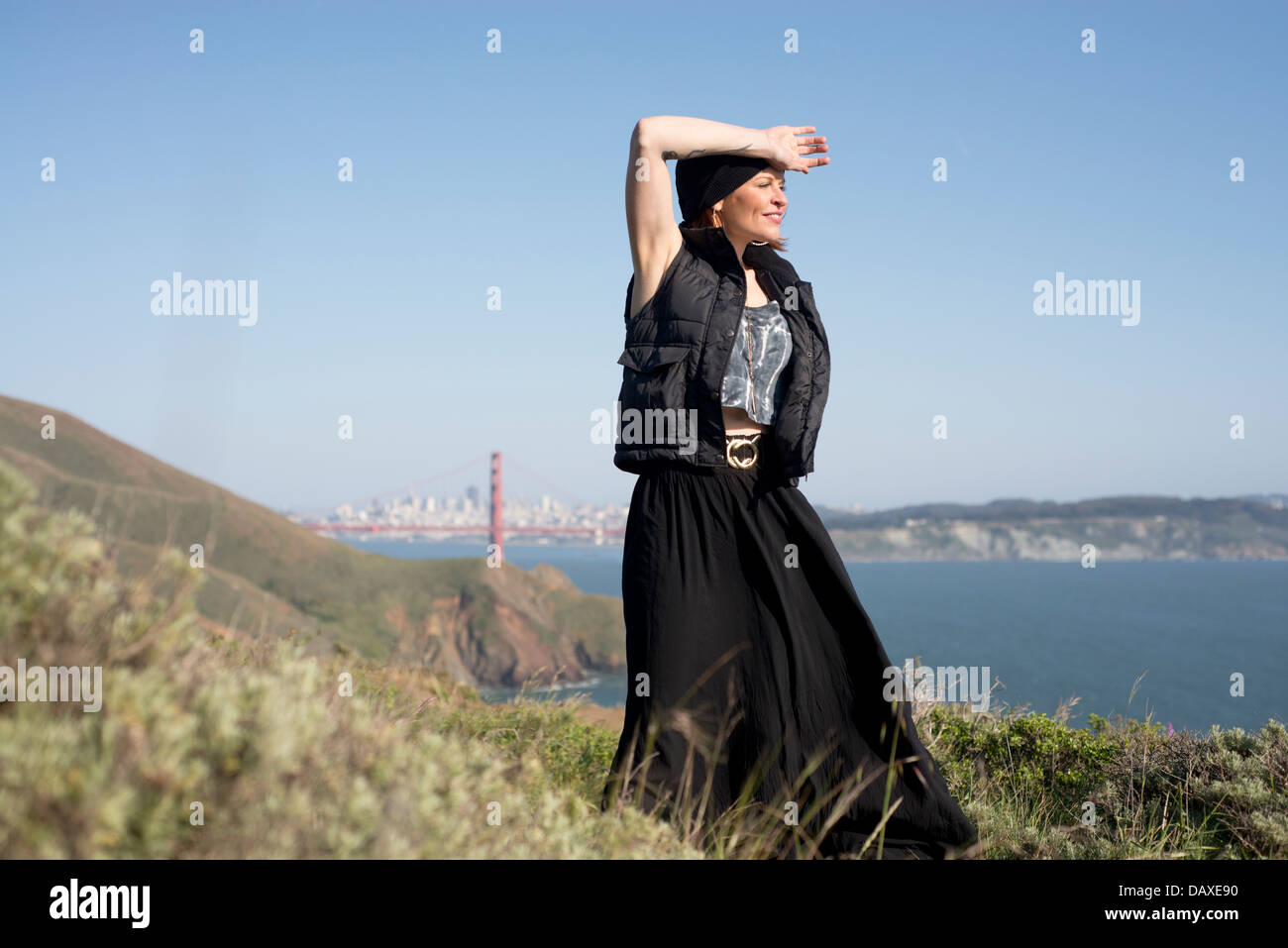 Reife attraktive Frau posiert mit Golden Gate Bridge im Hintergrund Stockfoto