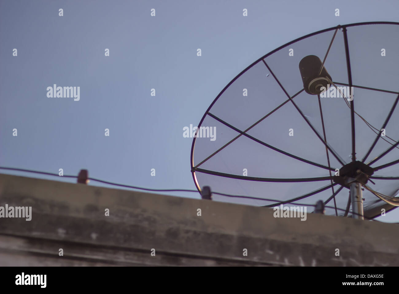 Eine Satellitenschüssel auf Haus blauen Himmelshintergrund Stockfoto