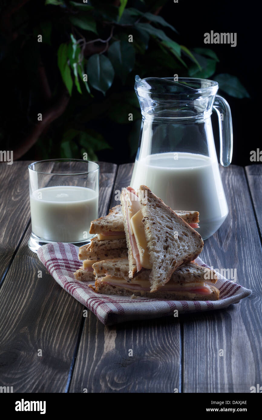 Sandwich und Krug mit Milch. Dunklen Ton. Stockfoto