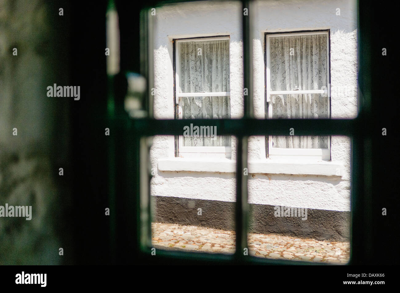 Blick aus einer Hütte Fenster im Fenster des gegenüberliegenden Hauses Stockfoto