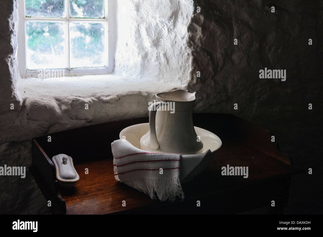 Altmodische Wäsche Krug und Becken durch das Fenster eines traditionellen irischen Bauernhauses Stockfoto