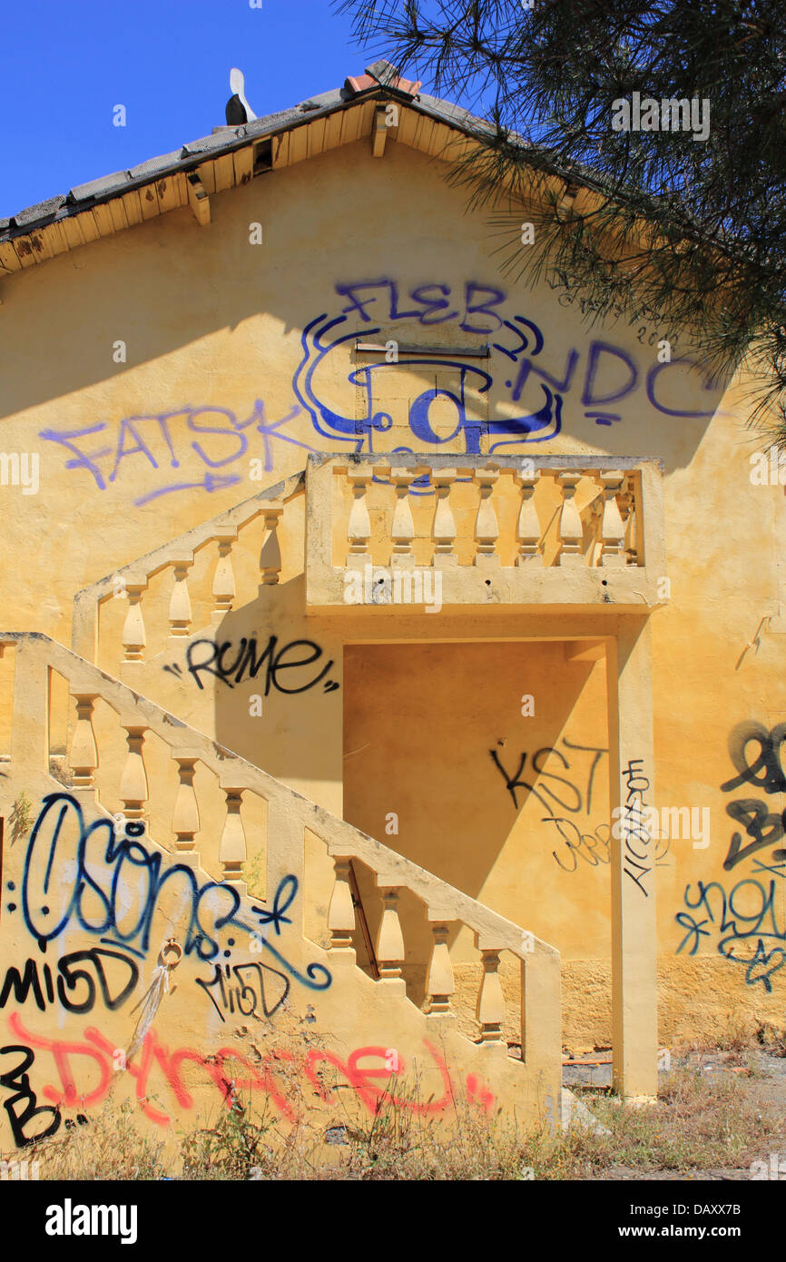 Gelbes Gebäude bedeckt in Graffiti, Corsica. Stockfoto