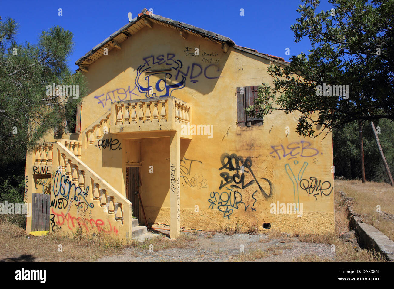 Gelbes Gebäude bedeckt in Graffiti, Corsica. Stockfoto