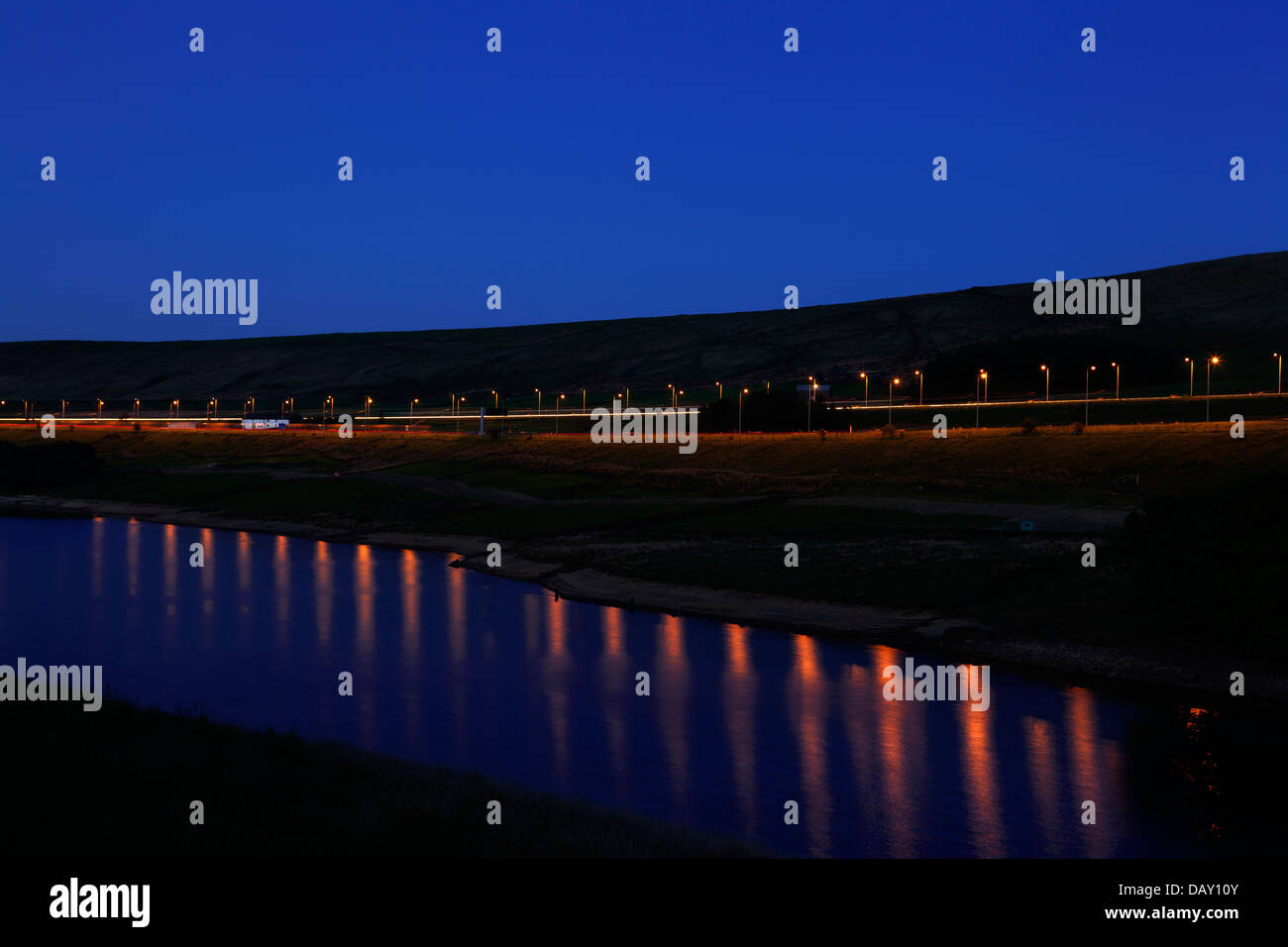 Autobahn M62 in der Dämmerung spiegelt sich im Stand Holz Reservoir, Rishworth, West Yorkshire Stockfoto