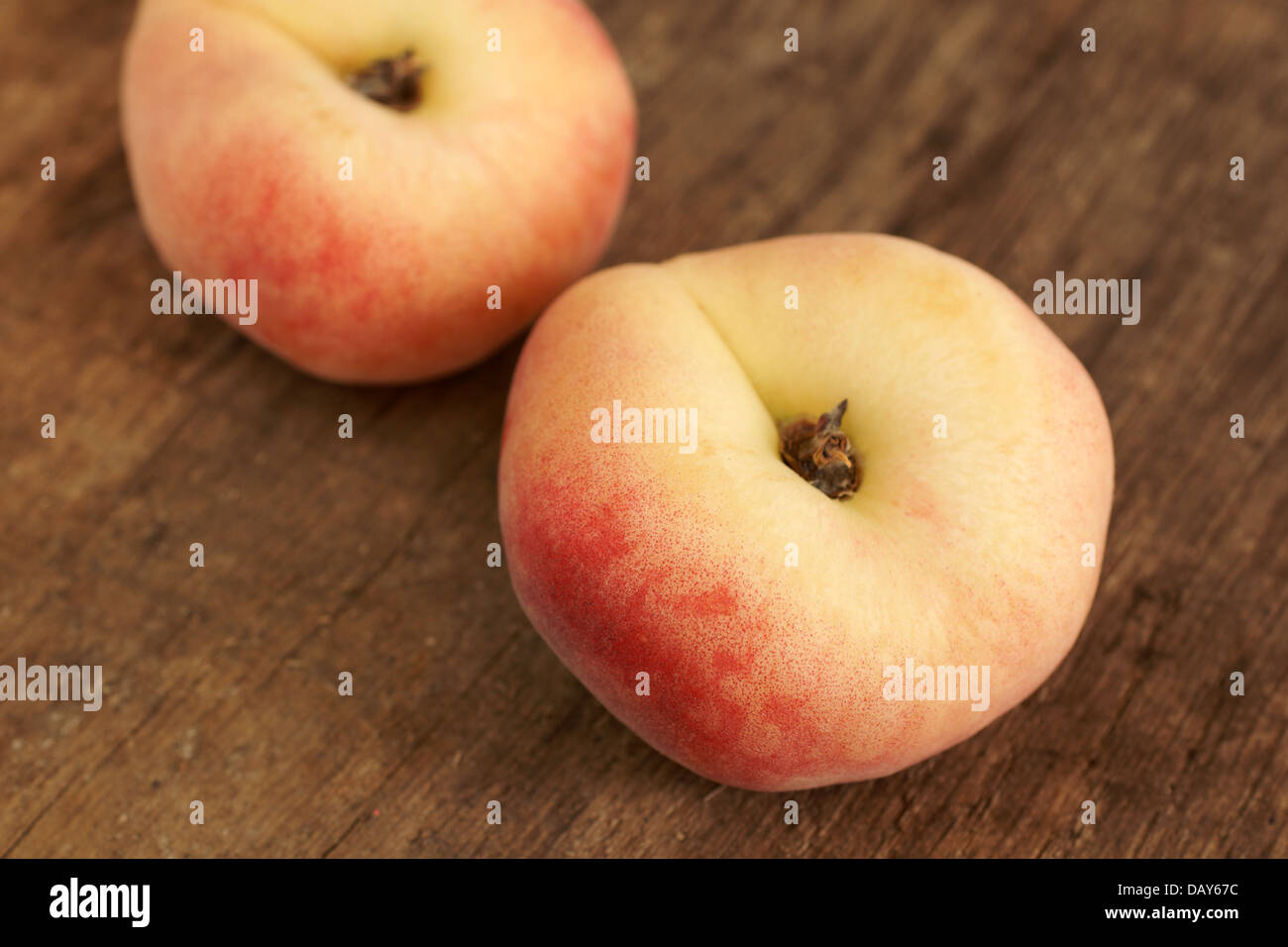 Donut Pfirsiche auch bekannt als Saturn Pfirsiche auf einem rustikalen Holztisch. Stockfoto