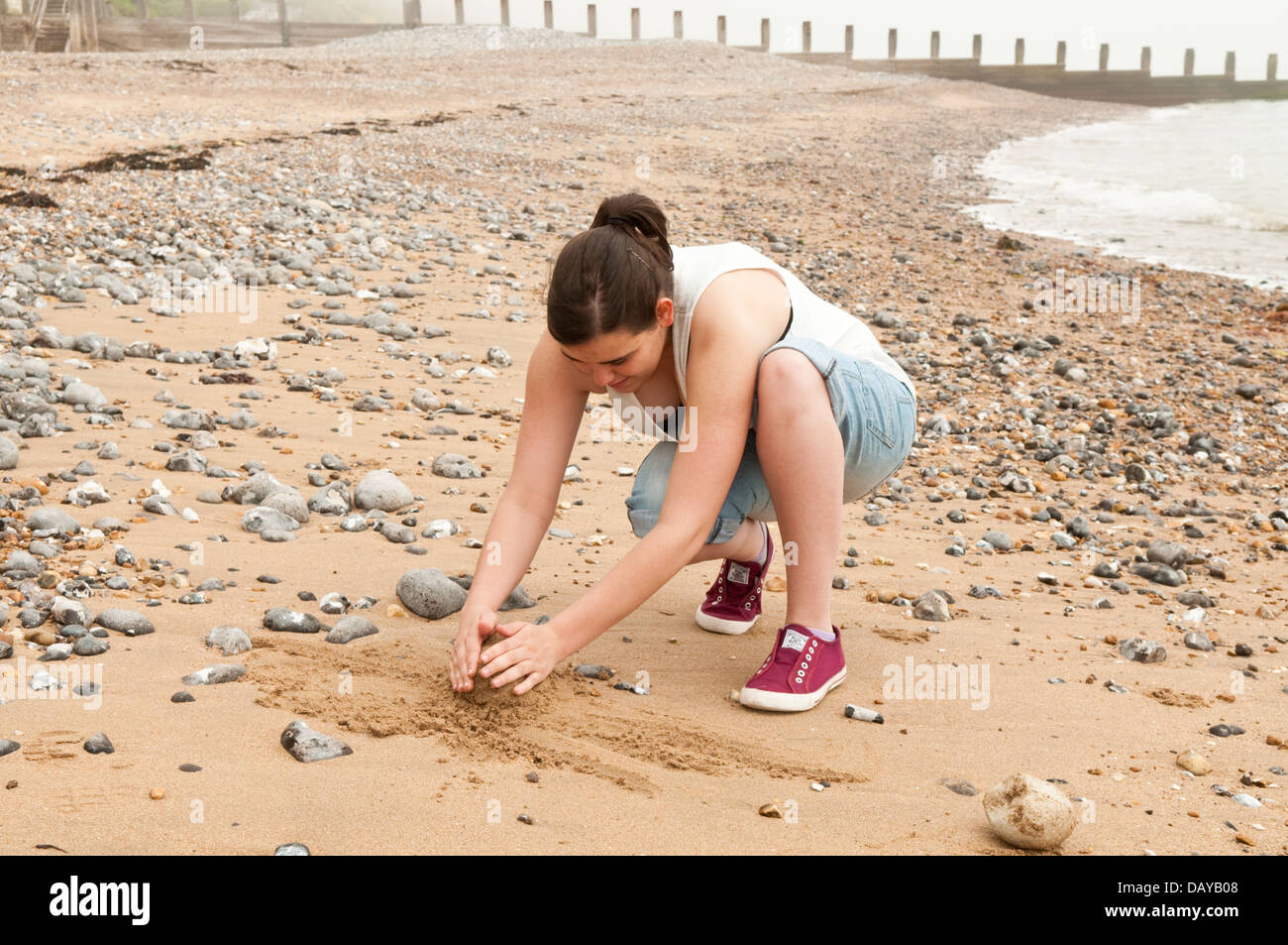 Junge Frau am Strand die Sand-Tiere Stockfoto