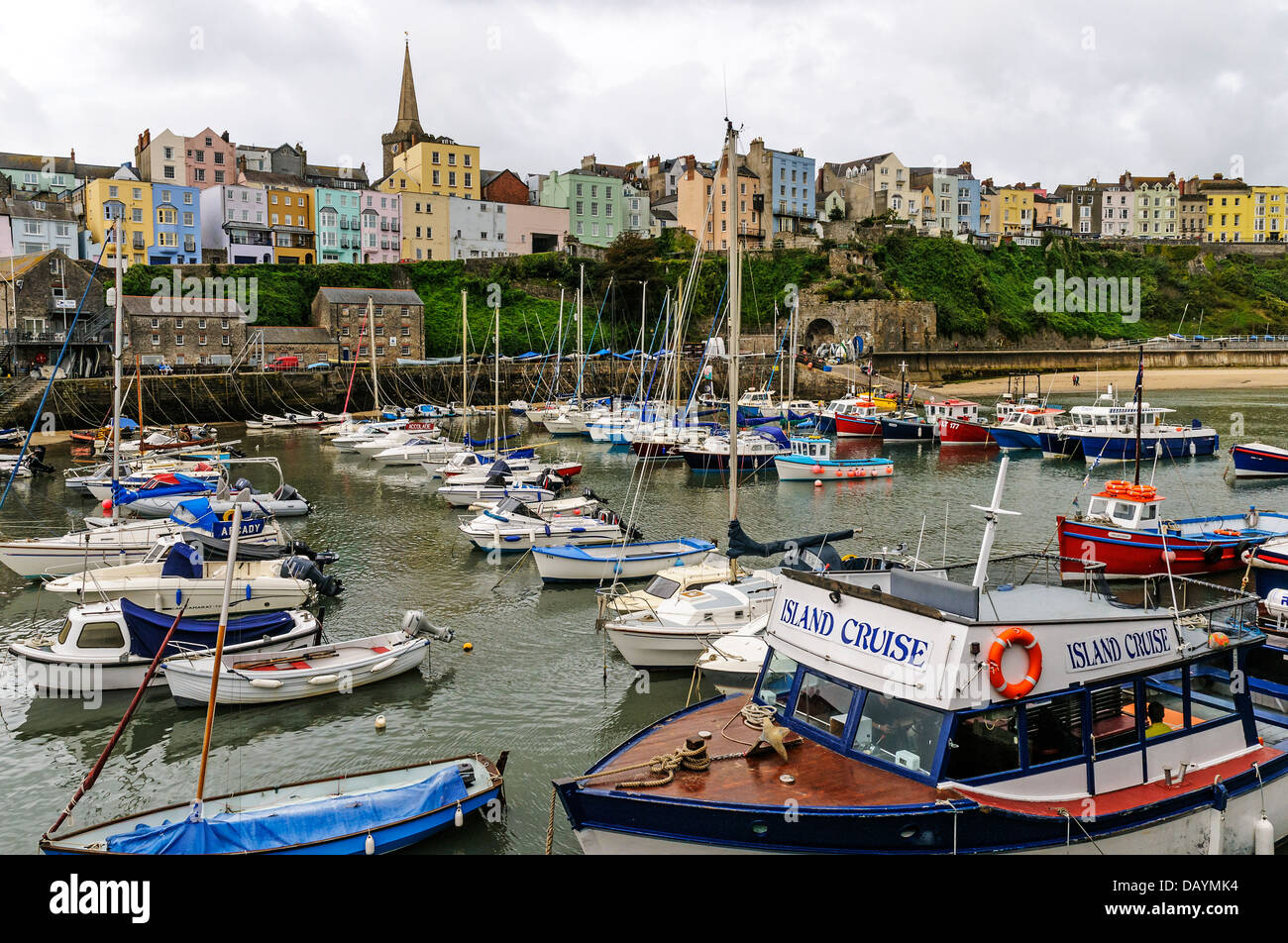 Pastell farbigen Pensionen mit Blick auf den mittelalterlichen Mauern, Goldstrand und eine kleine Flotte von Angel- und Freizeitboote, Tenby Stockfoto