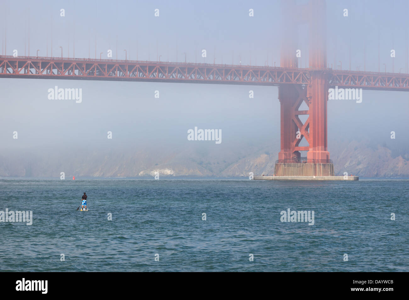 Stehen Sie auf dem Paddle Boarder und der Golden Gate Bridge, während der Nebel am Morgen steigt Stockfoto