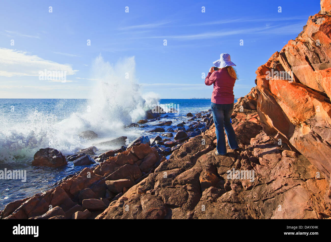 hübsche Frau, die ein Foto von Wellen brechen über die Felsen Felsenküste am Hallett Cove Adelaide South Australia Australia Stockfoto