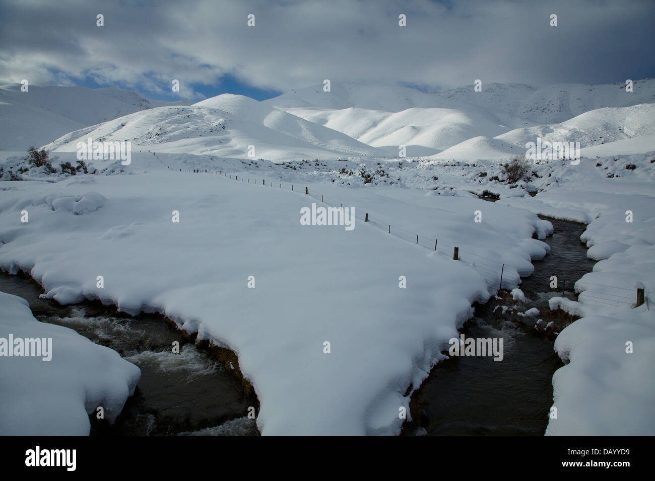 Bäche und verschneite Felder neben "Pigroot" (State Highway 85), Otago, Südinsel, Neuseeland Stockfoto