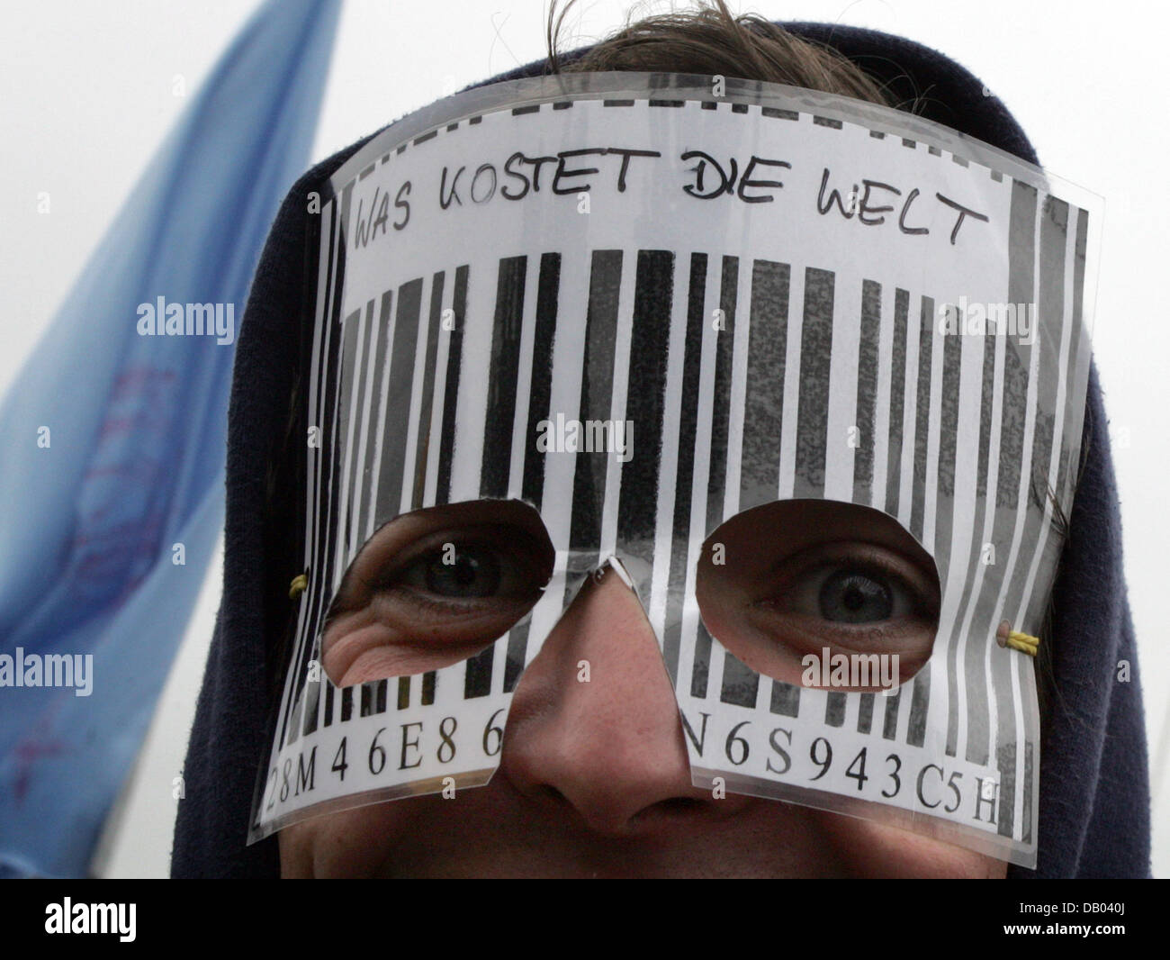Ein Demonstrator trägt eine Maske Lesung 'Was Kostet Die Welt' ('wieviel ist die Welt?") zu einer Massenkundgebung gegen den G8-Staats-Gipfel, die am Hafen von Rostock, Deutschland, 2. Juni 2007 im nahe gelegenen Heiligendamm stattfinden. Foto: Rainer Jensen Stockfoto