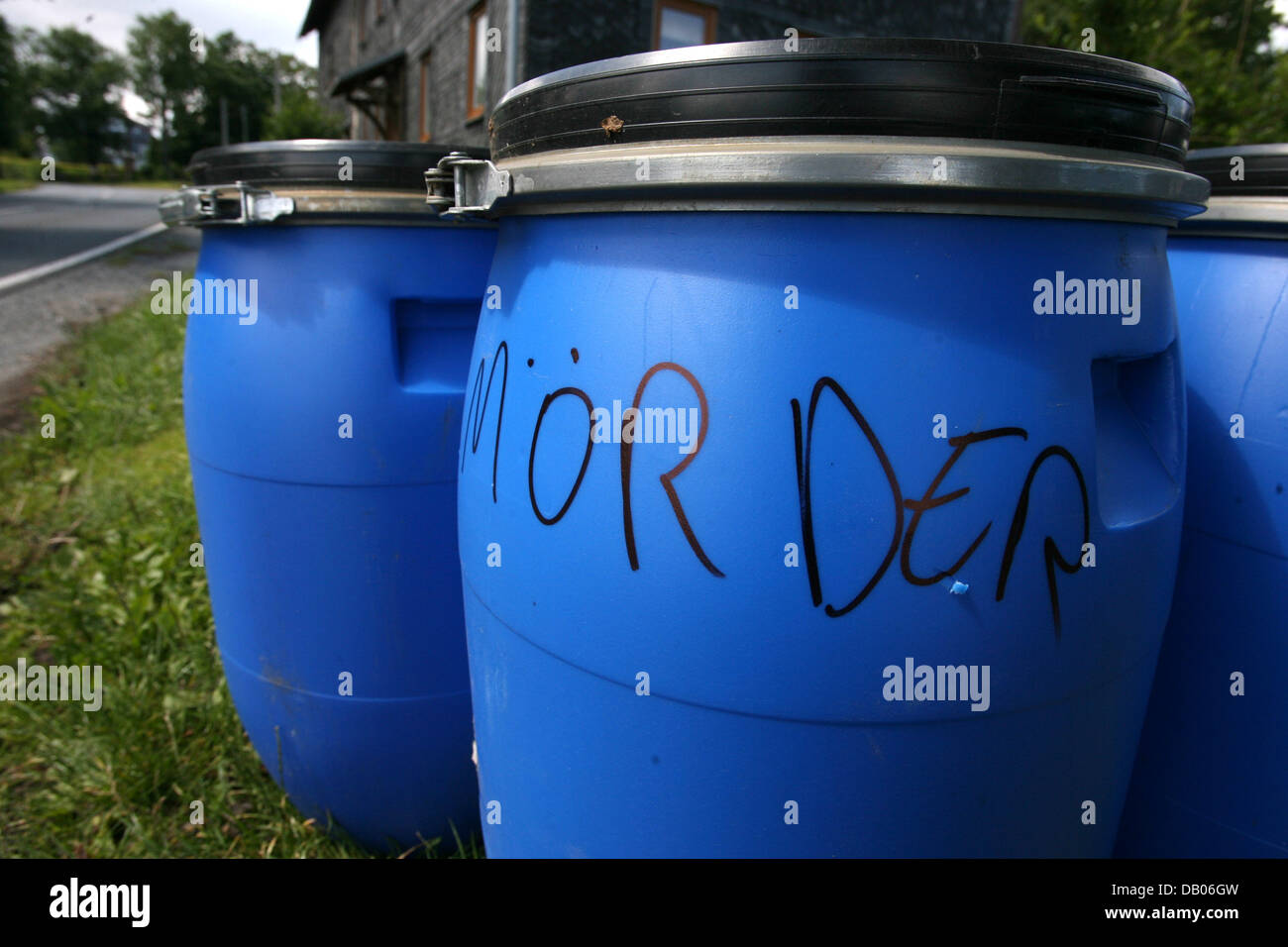 Das Bild zeigt blauen Container, die verwendet werden, um einer getöteten Gänse Bevölkerung, beschriftet mit "Mörder" in Hoheneiche, Deutschland, 7. Juli 2007 zu entfernen. Die gefährlichere Vogelgrippe brach in einem deutschen Geflügelfond zum ersten Mal in mehr als einem Jahr. Das Friedrich-Loeffler-Institut (FLI) hatte eine tote Gänse mit dem H5N1-Virus diagnostiziert. Daher vier Gees und fünf Enten im Besitz von einem p Stockfoto