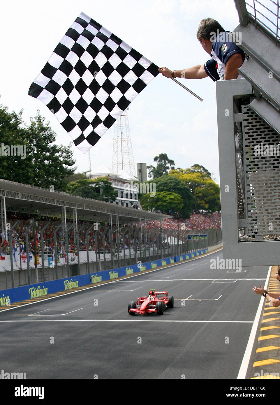 Finnischer Formel1-Fahrer Kimi Räikkönen Ferrari geht die Zielflagge als er die Ziellinie in der Formel 1 Grand Prix von Brasilien an Carlos Pace Rennstrecke in Interlagos in der Nähe von Sao Paulo, Brasilien, 21. Oktober 2007 überquert. Foto: ROLAND WEIHRAUCH Stockfoto