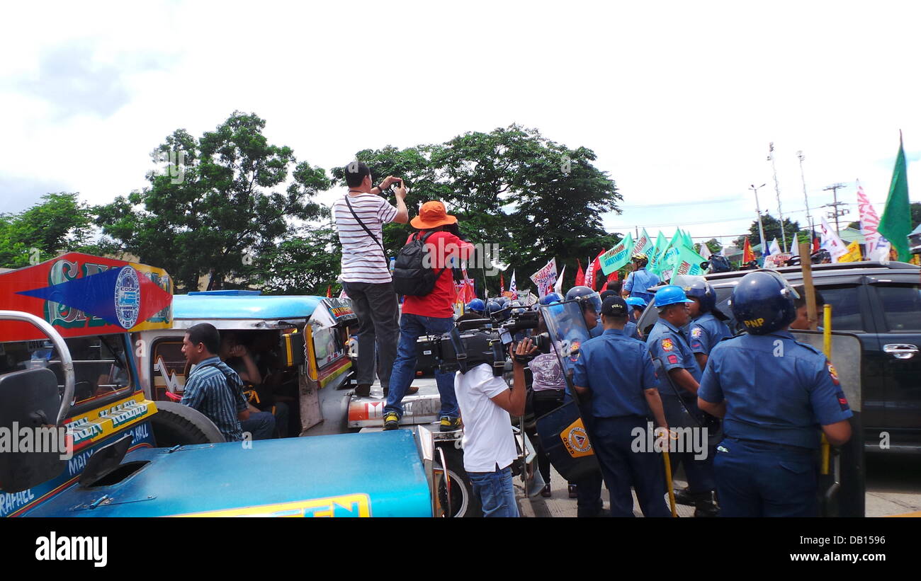 Quezon City, Philippinen. 22. Juli 2013. Medienrummel Event wo Medien Männer lag bei einem vorbeifahrenden Jeepney für die Aufnahme von Tausenden von Polizisten in Quezon City, während der Zustand der Nation Adresse (SONA) von Präsident Benigno Aquino Jr. verstreut wurden, andere militante Gruppen zu verbarrikadieren, die unzufrieden mit der Leistung des Präsidenten sind. Nach den Gruppen haben sie keine Verbesserung der Lebensbedingungen der Filipinos für die letzten drei Jahre des Präsidenten gesehen. Bildnachweis: Sherbien Dacalanio/Alamy Live-Nachrichten Stockfoto