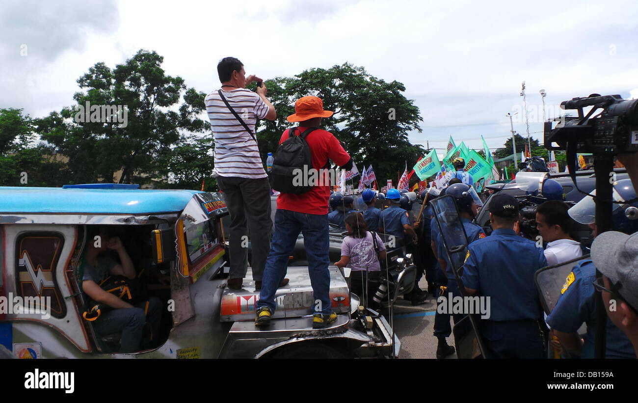 Quezon City, Philippinen. 22. Juli 2013. Medienrummel Event wo Medien Männer lag bei einem vorbeifahrenden Jeepney für die Aufnahme von Tausenden von Polizisten in Quezon City, während der Zustand der Nation Adresse (SONA) von Präsident Benigno Aquino Jr. verstreut wurden, andere militante Gruppen zu verbarrikadieren, die unzufrieden mit der Leistung des Präsidenten sind. Nach den Gruppen haben sie keine Verbesserung der Lebensbedingungen der Filipinos für die letzten drei Jahre des Präsidenten gesehen. Bildnachweis: Sherbien Dacalanio/Alamy Live-Nachrichten Stockfoto