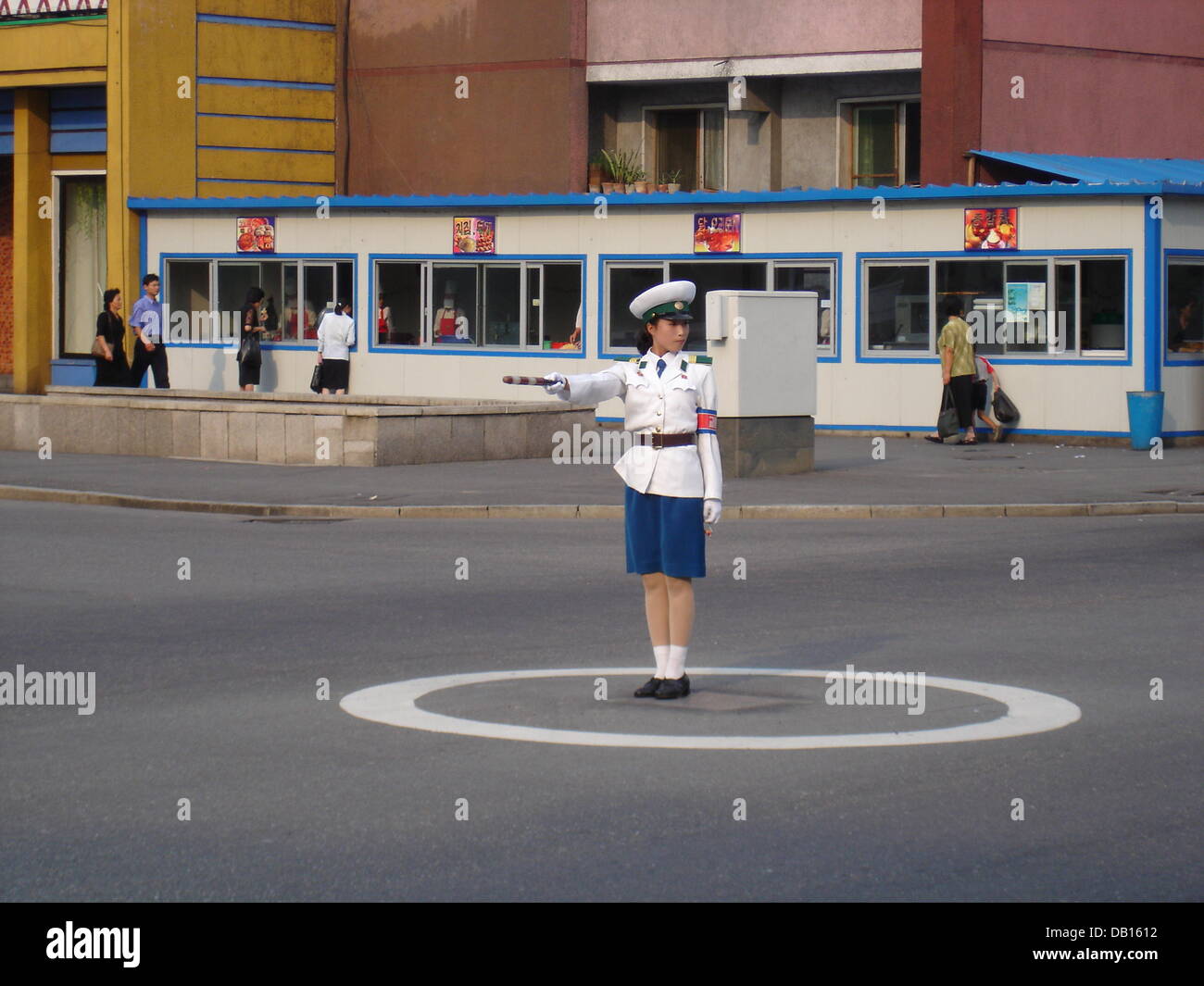 Eine Polizistin Verkehr steuert den bescheidenen Verkehr während sie mitten in einem weißen Kreis auf einer Straße in der Hauptstadt Pyongyang, Nordkorea, 12. September 2007 steht. Anstelle von Ampeln regulieren Menschen Verkehr in der koreanischen Hauptstadt, mit insgesamt 6 Schichten pro Tag alle zwei Stunden ändern. Foto: Thomas Gutschker Stockfoto