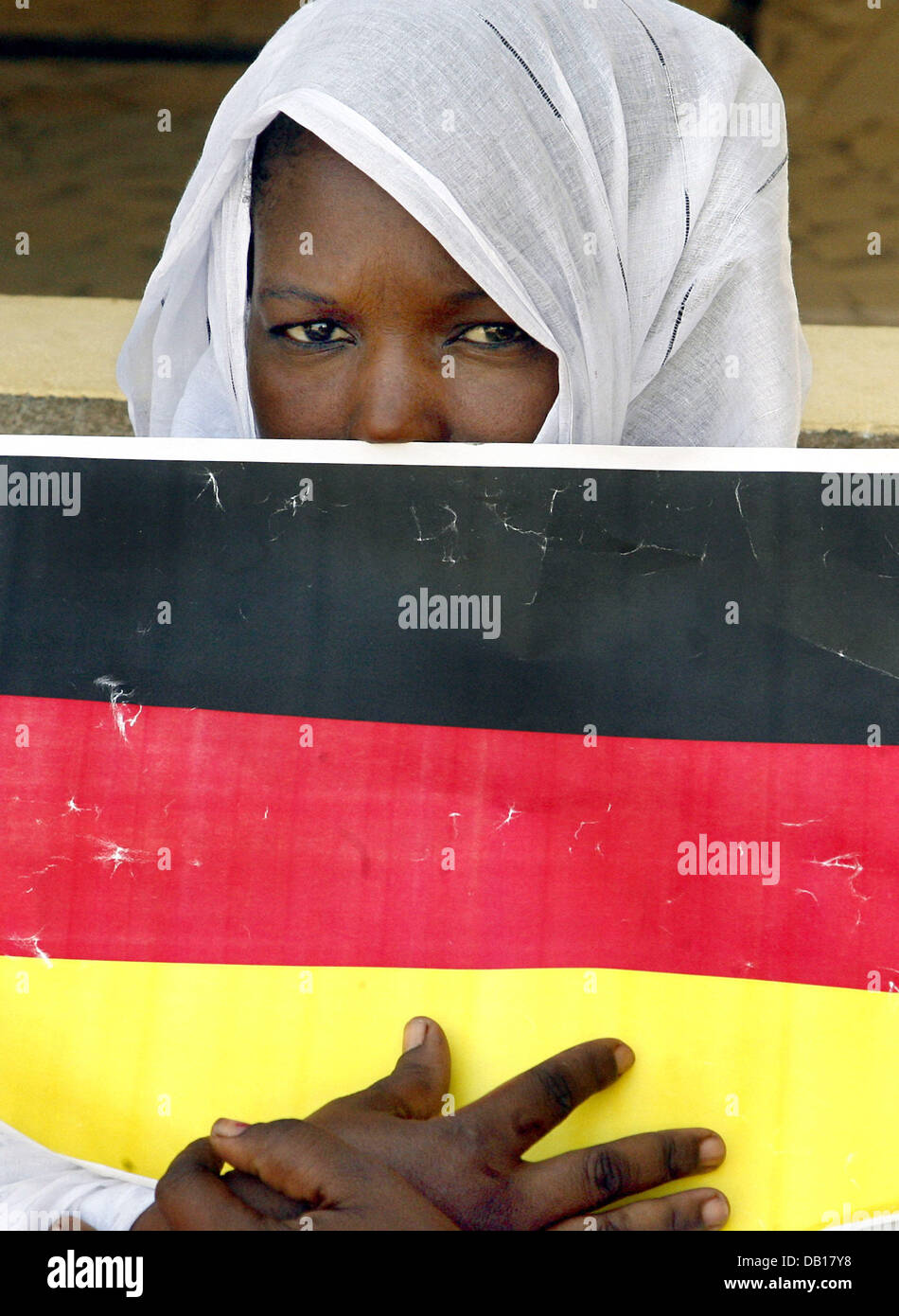 Eine junge Frau verbirgt sich hinter einer Deutschland-Flagge vor der Ankunft der deutschen Präsidentengattin Eva Koehler, an der Schule für behinderte Kinder in der Hauptstadt Nouakchott, Mauretanien, 14. November 2007. Das deutsche Staatsoberhaupt und seine Frau bezahlen einen dreitägigen Staatsbesuch in den nordafrikanischen Staaten Algerien, Mauretanien und Malta. Foto: Wolfgang Kumm Stockfoto