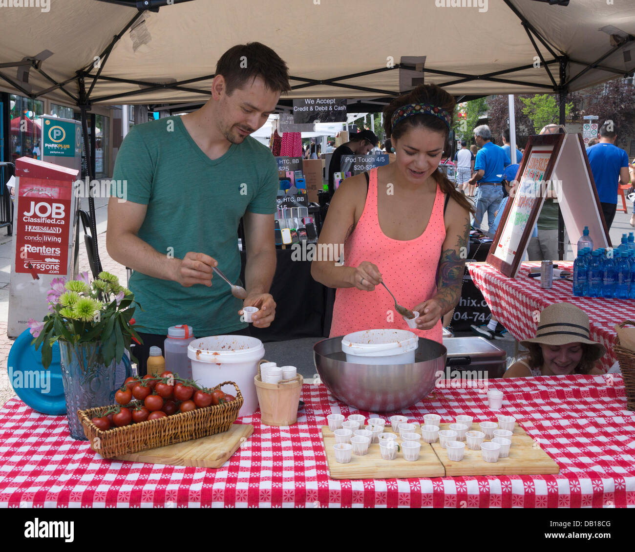 Calgary, Alberta. 21. Juli 2013. Mann und Frau Löffel Proben für die Salsa-Verkostung contest am Sonntag, 21. Juli 2013 während der Sonne und Salsa Festival in Kensington Bereich von Calgary, Alberta, Kanada. Diese jährliche Veranstaltung sammelt Spenden für wohltätige Zwecke. Bildnachweis: Rosanne Tackaberry/Alamy Live-Nachrichten Stockfoto