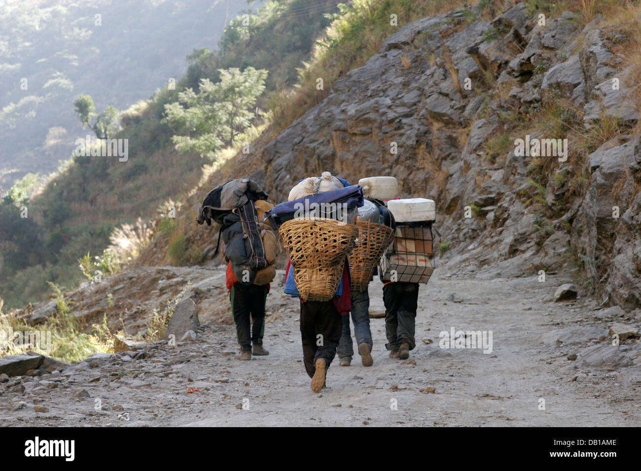 Träger, die schwere Last zu tragen, auf der Spur im Annapurna Conservation Area, Annapurna Circuit, Nepal Stockfoto