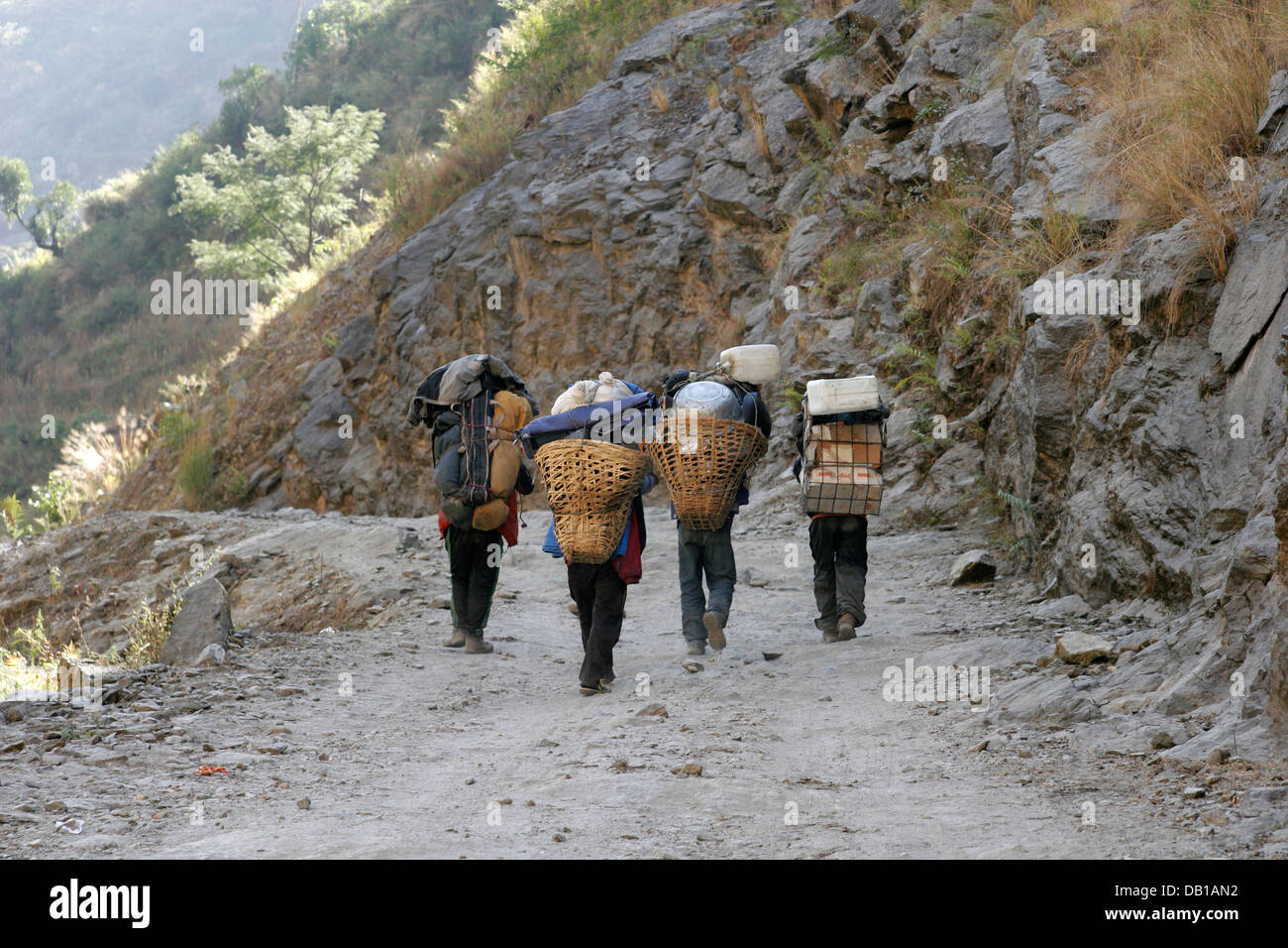 Träger, die schwere Last zu tragen, auf der Spur im Annapurna Conservation Area, Annapurna Circuit, Nepal Stockfoto