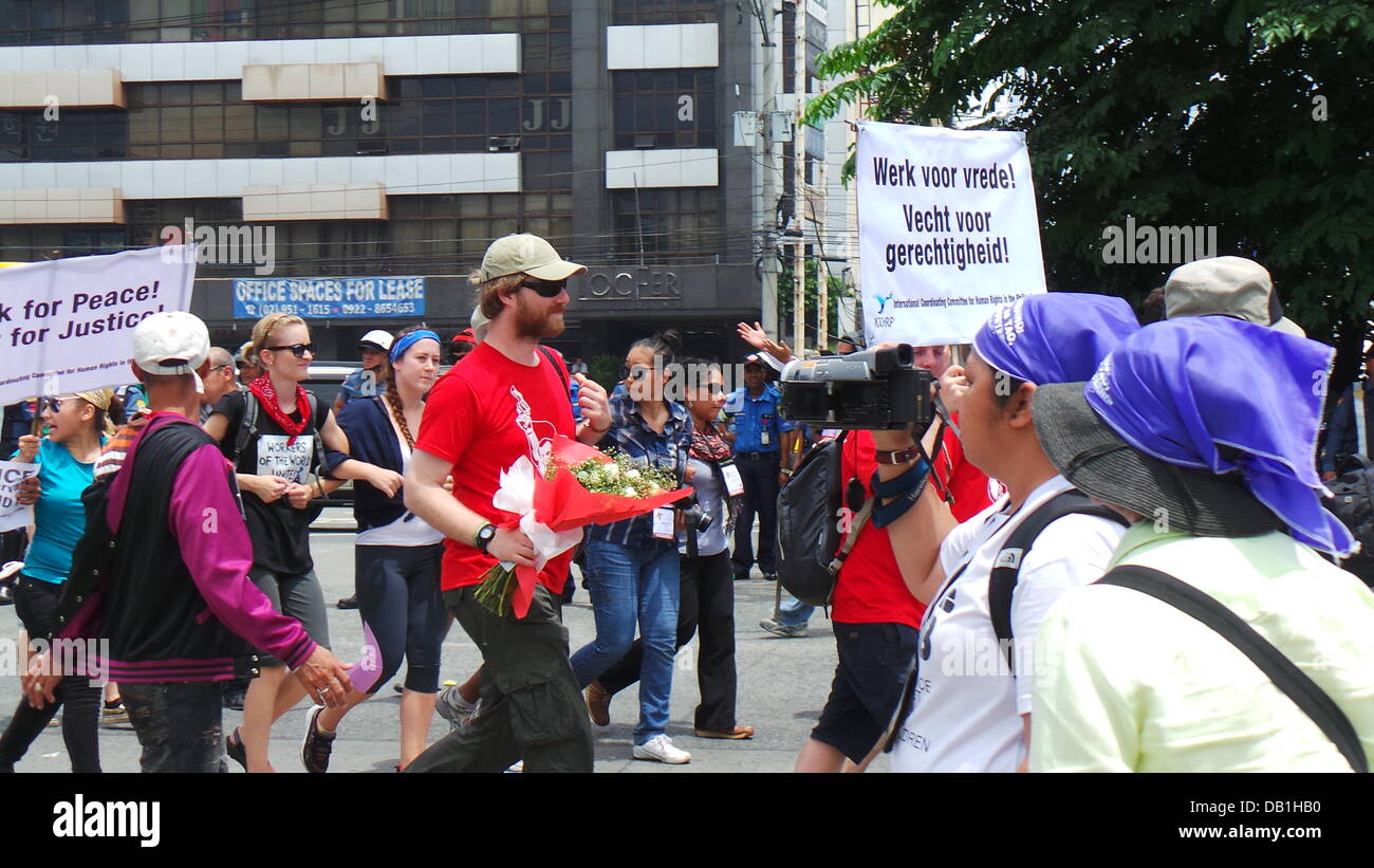Quezon City, Philippinen. 22. Juli 2012. Ein Vertreter von internationalen Koordinierungsausschusses für Menschenrechte (ICCHR) hält einen Blumenstrauß von Polizisten während der Anti-SONA-Rallye gegeben in Quezon City Kredit statt: Sherbien Dacalanio/Alamy Live News Stockfoto