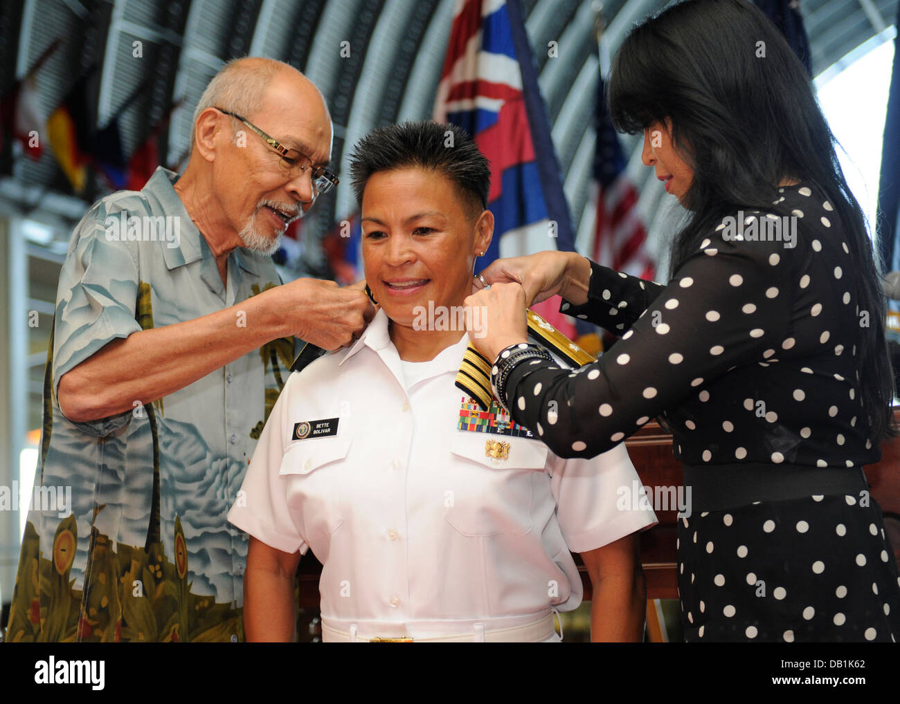 Rear Admiral Bette Bolivar, Kommandant, Navy Region Nordwest, bekommt ihr Einstern Schulterklappen angebracht, von ihrem Vater Ted Cereno Stockfoto