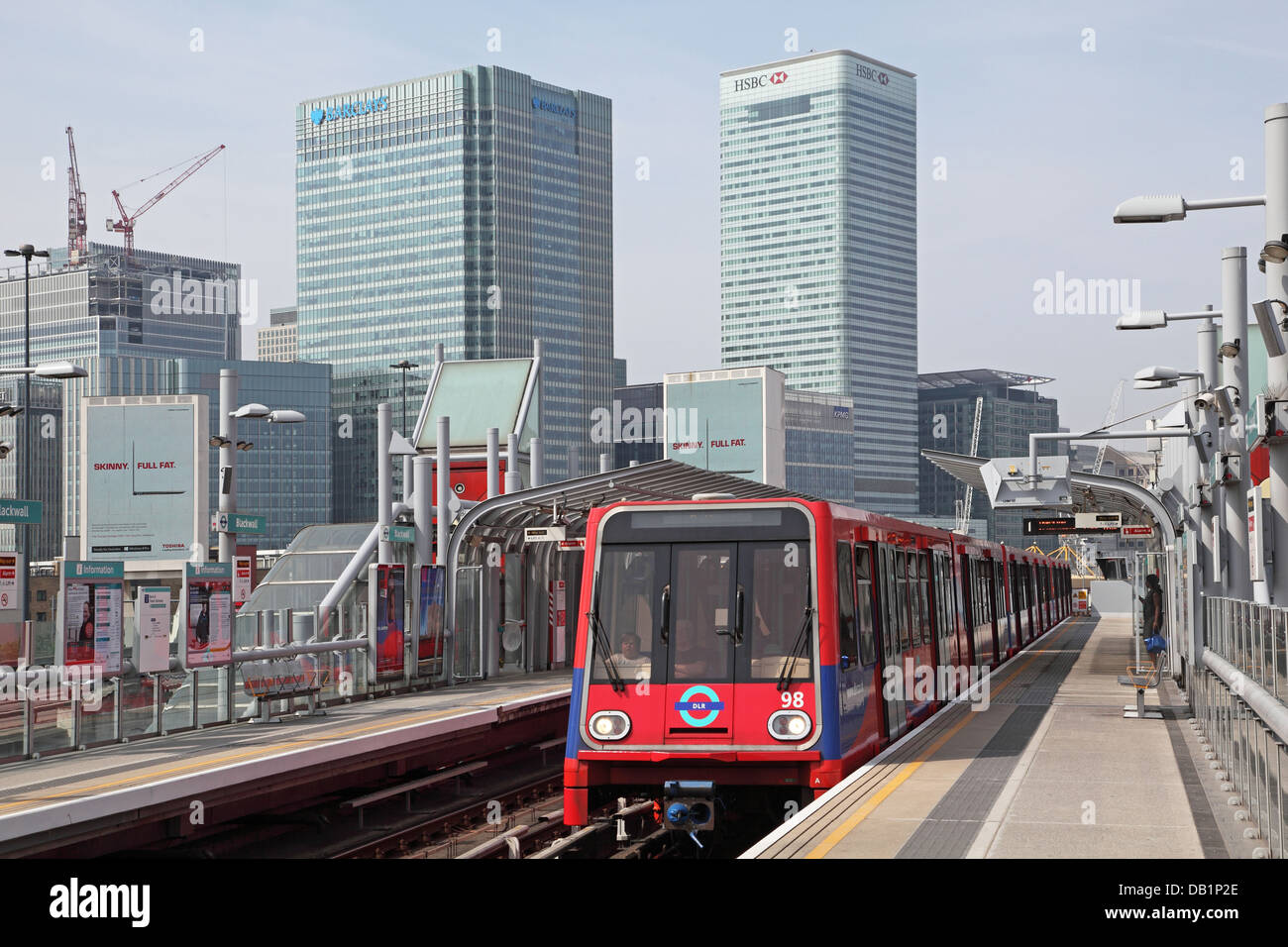 Ein London Docklands Light Railway Zug kommt an Pappel-Station mit dem Geschäftsviertel Canary Wharf im Hintergrund. Stockfoto