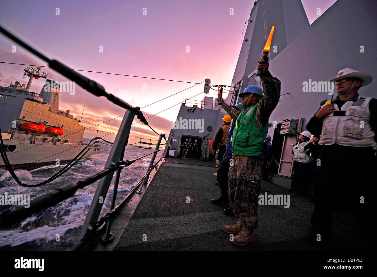 Bootsmann der Mate 2. Klasse Cory Schilde Signale an den Military Sealift Command Flotte Nachschub Öler USNS Henry J. Kaiser (T-AO 187) während einer Auffüllung auf hoher See an Bord der amphibischen Transportschiff der Dock USS New Orleans (LPD-18). New Orleans ist Teil Stockfoto